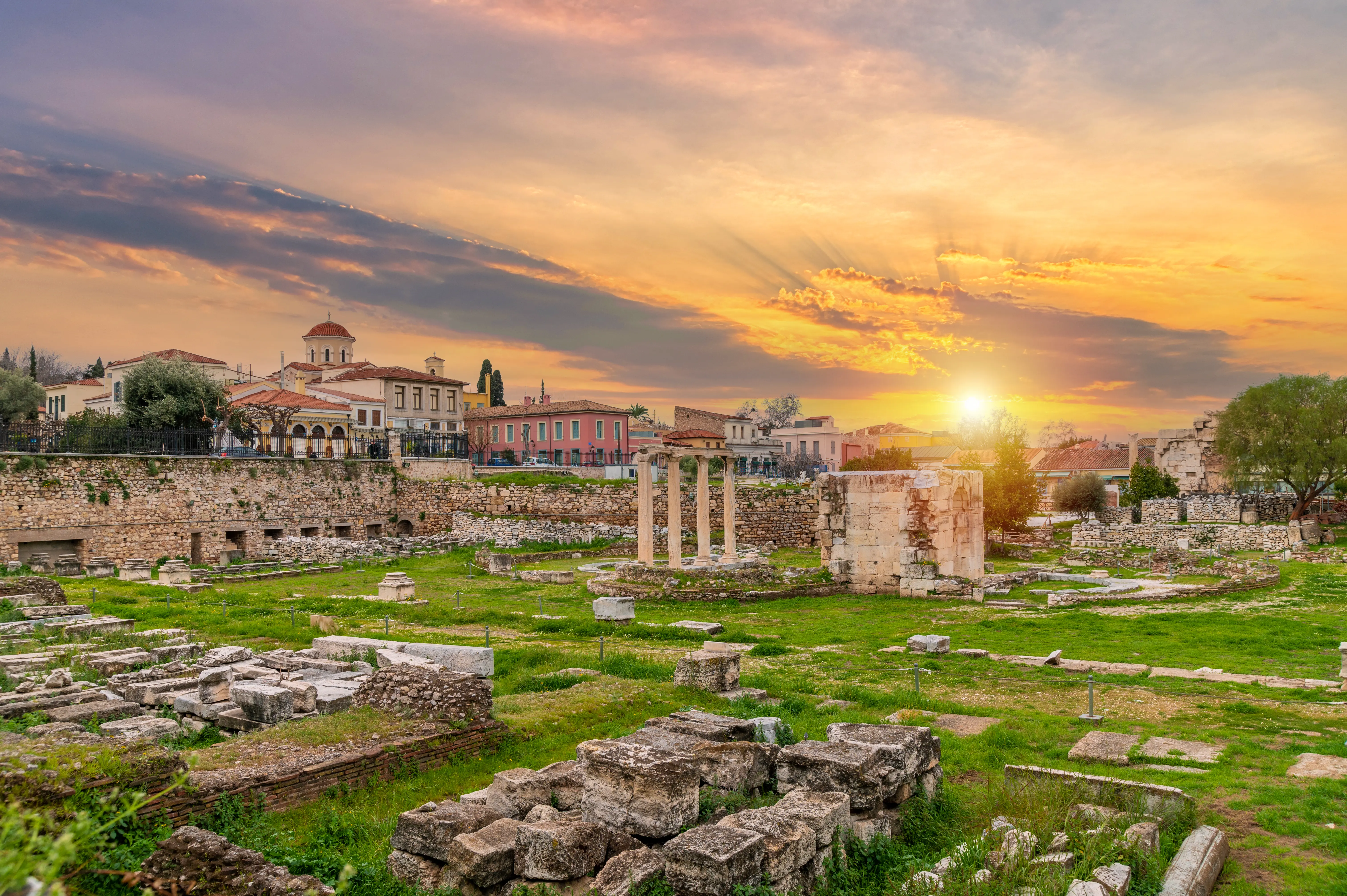 Outdoor image of a sunset over the Hadrian library archaeological site in Athens.