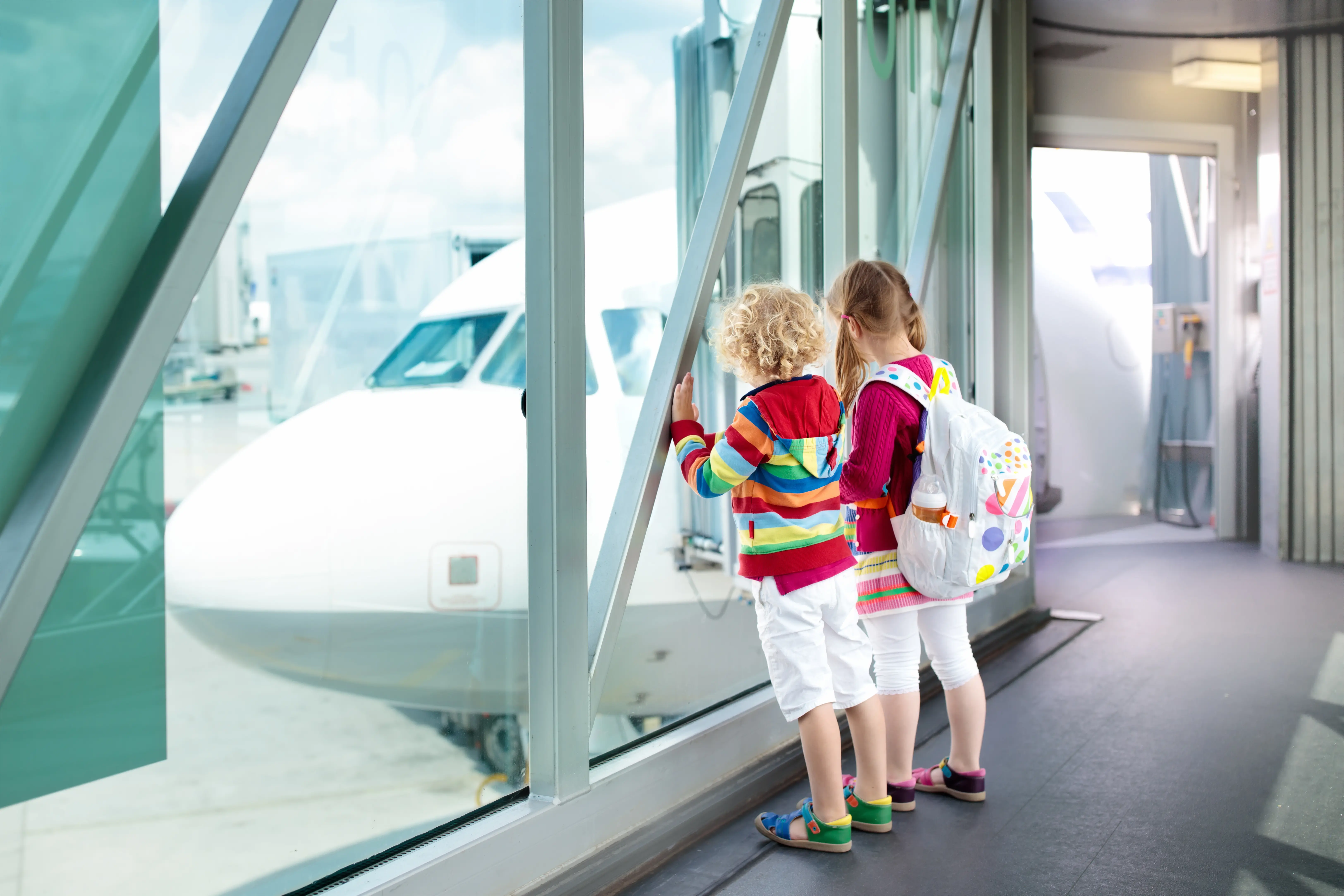 kids looking out window at airport