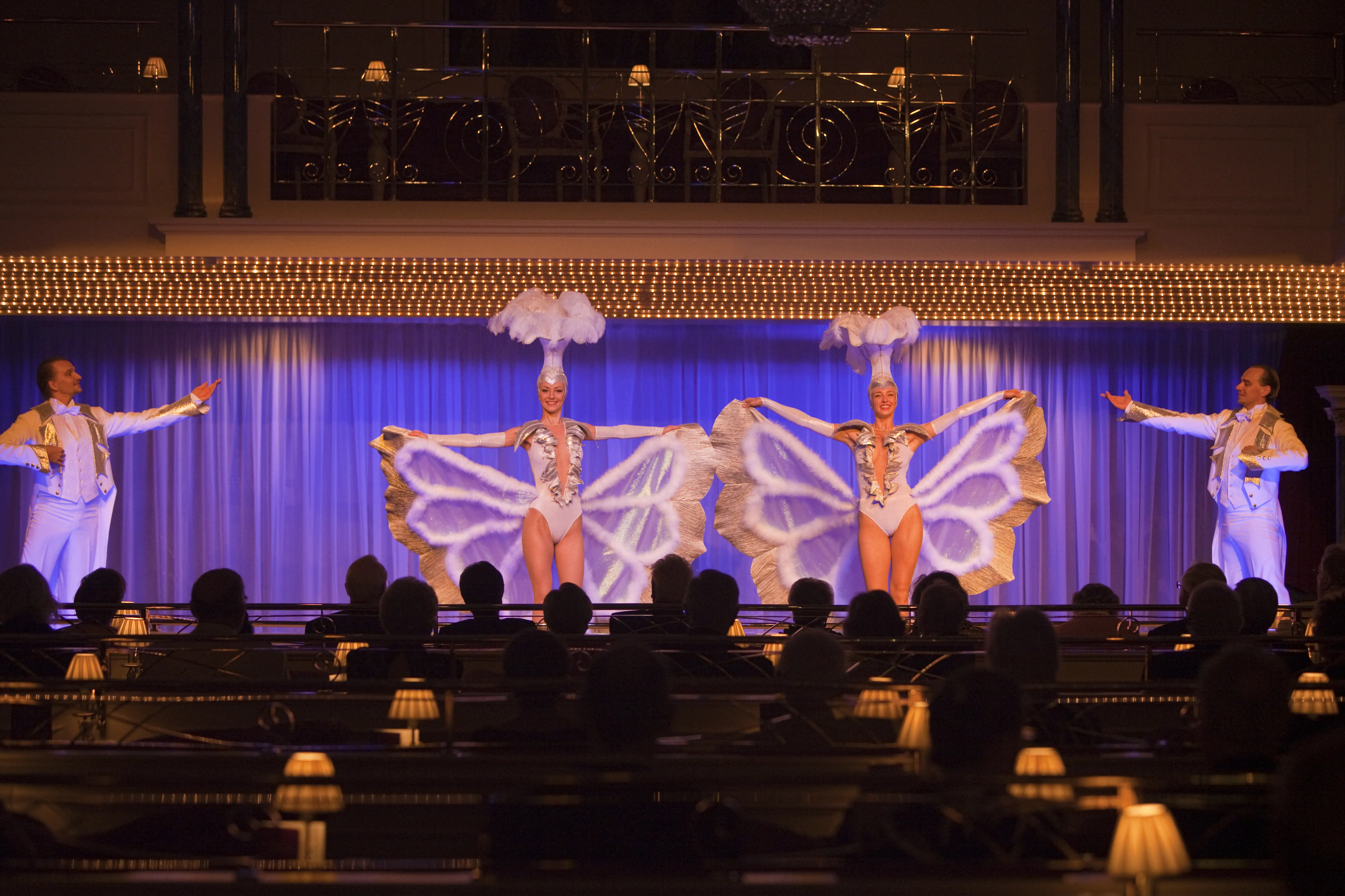 Image of a dance show being performed in the theater of a cruise ship.