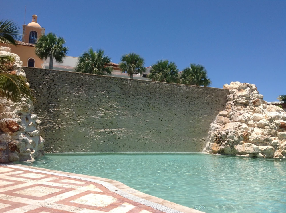 Outdoor pool surrounded by rocks and a stone wall at Sanctuary AlSol.