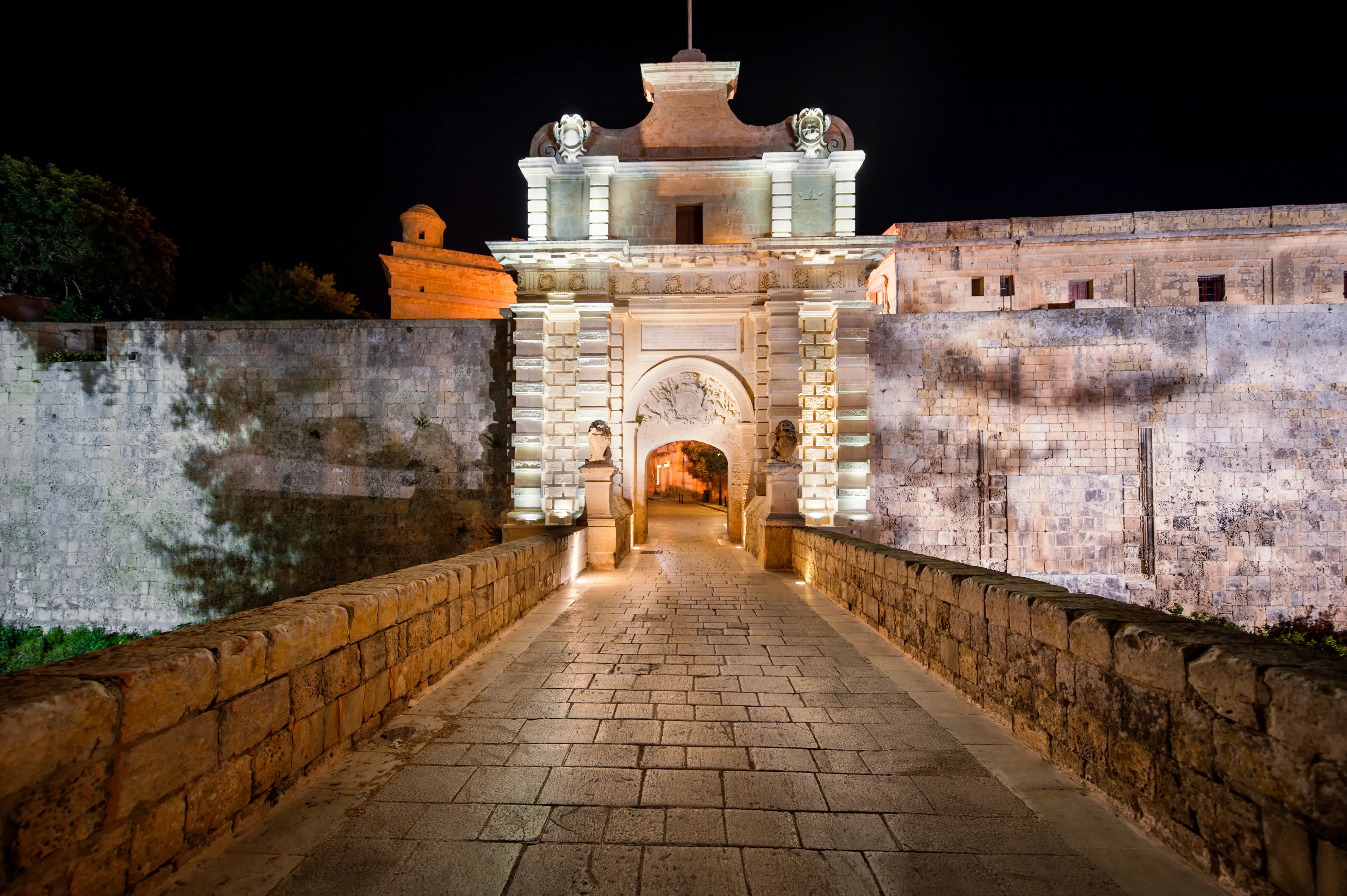 Outdoor image of the city gate of Mdina Malta at nighttime.