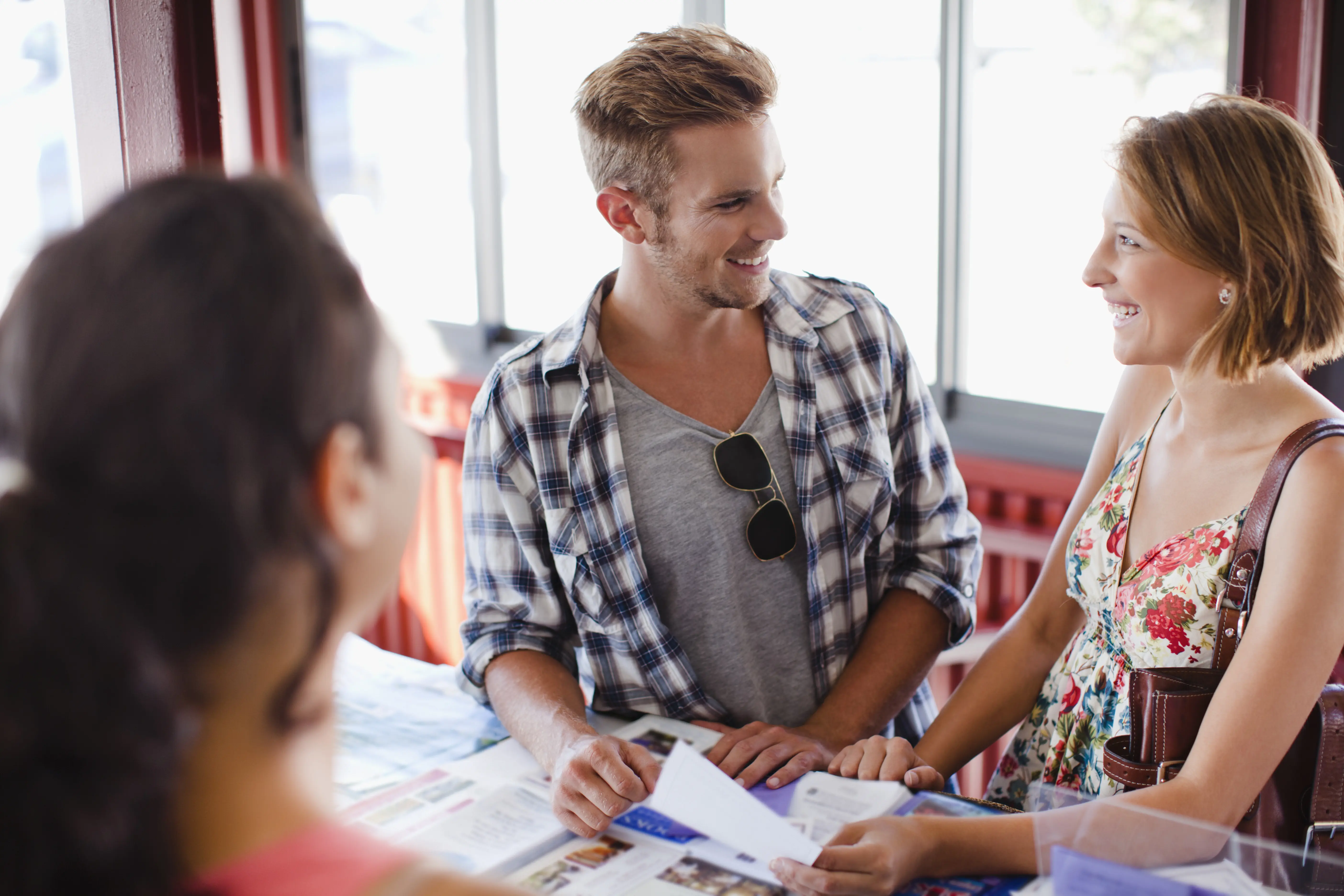 Image of a couple getting help at a tourist planning desk.