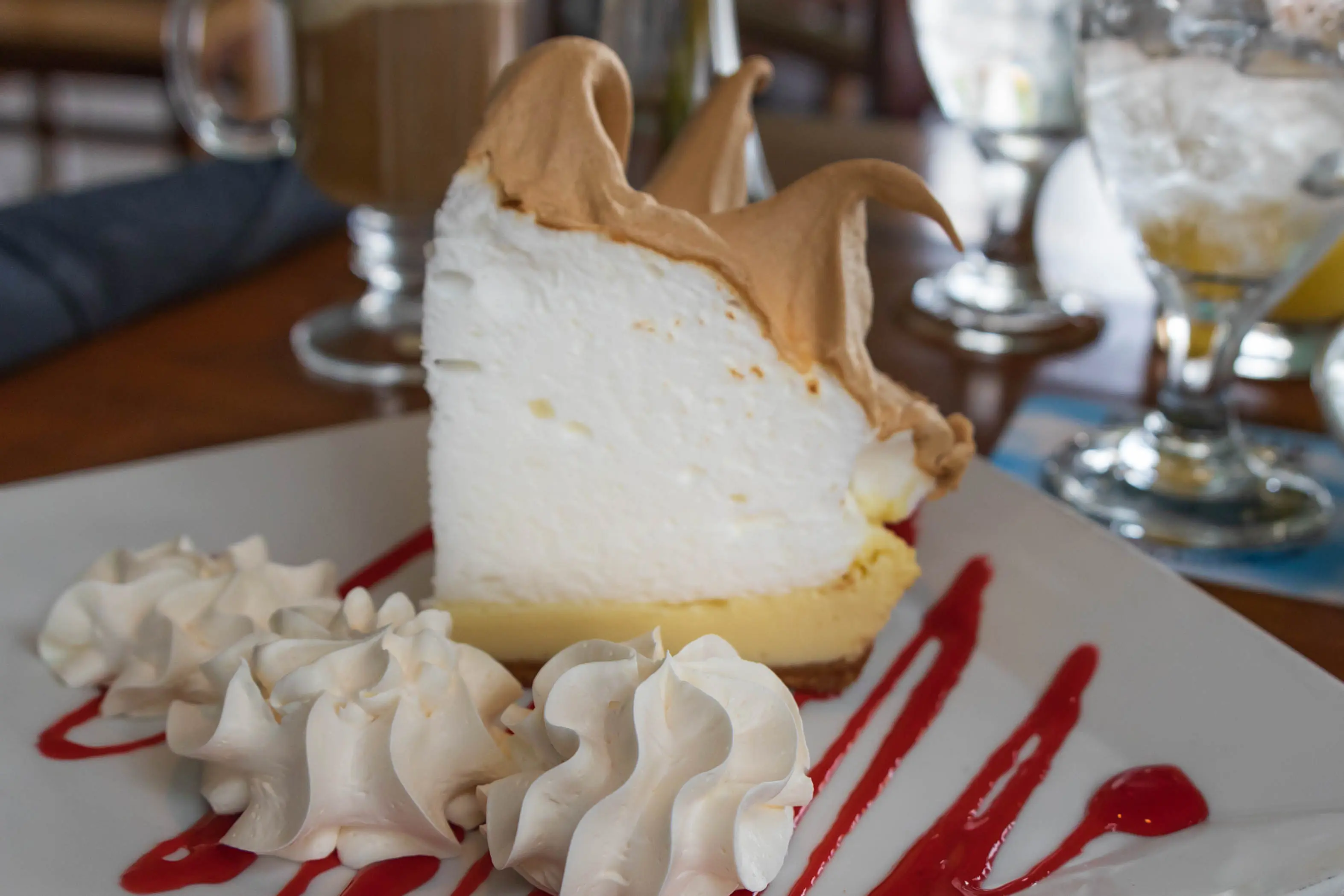 One slice of key lime pie with whipped cream on a plate.