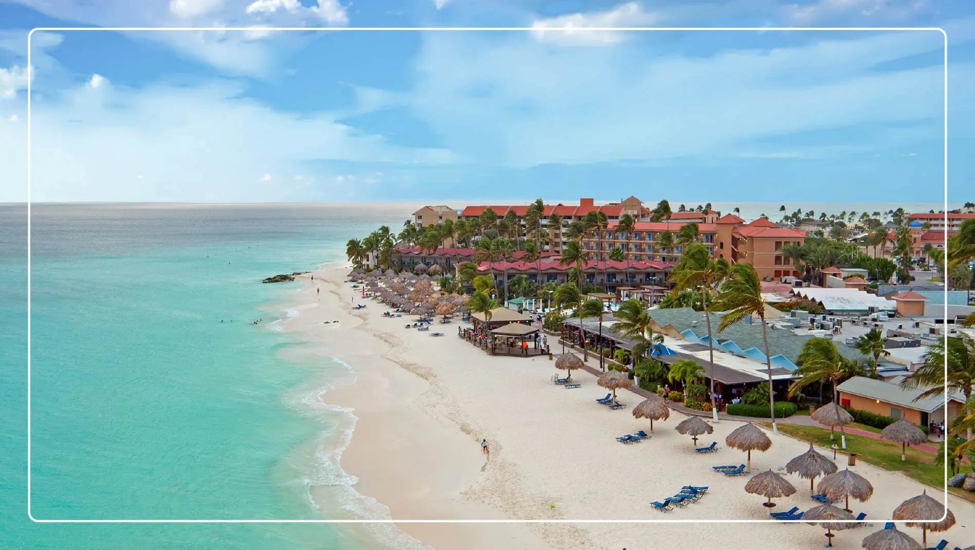 A beach in Aruba with an all-inclusive resort in the background.