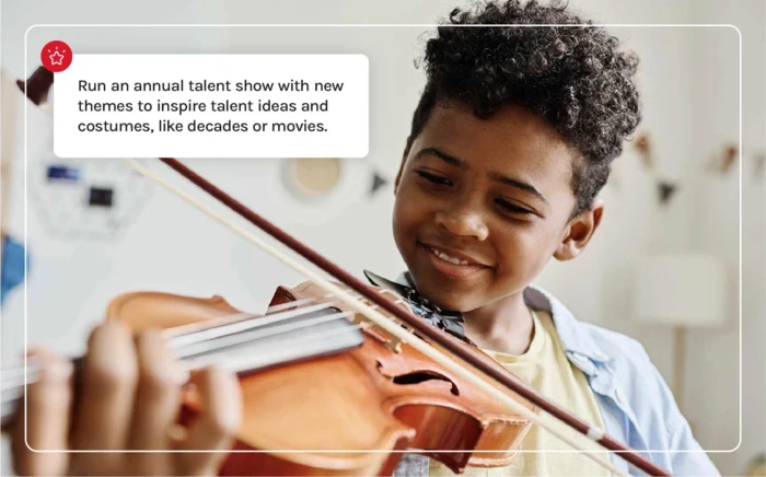 A young kid playing his violin in a talent show. 