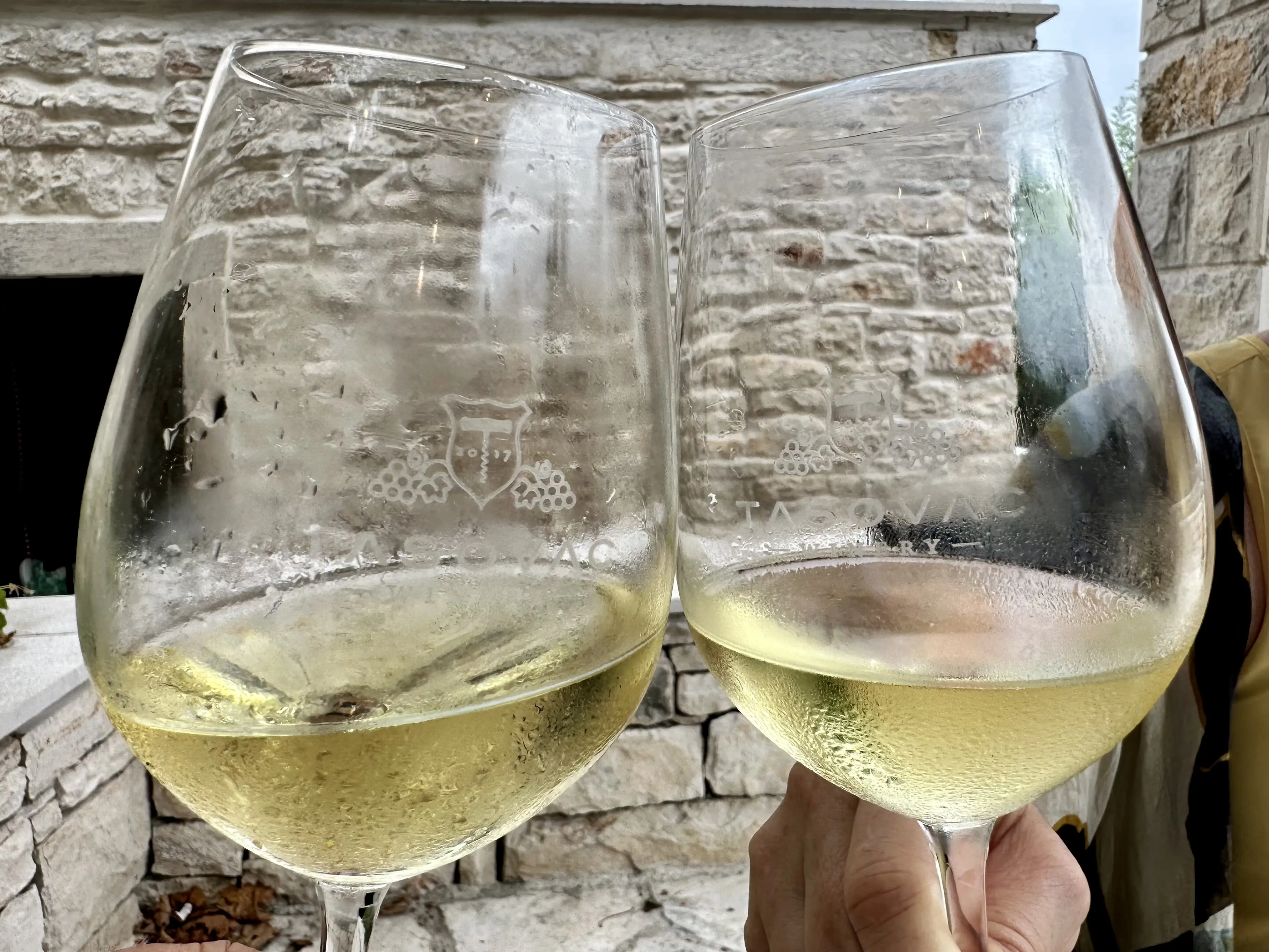 Image of two clinking wine glasses, on Korčula in Croatia.