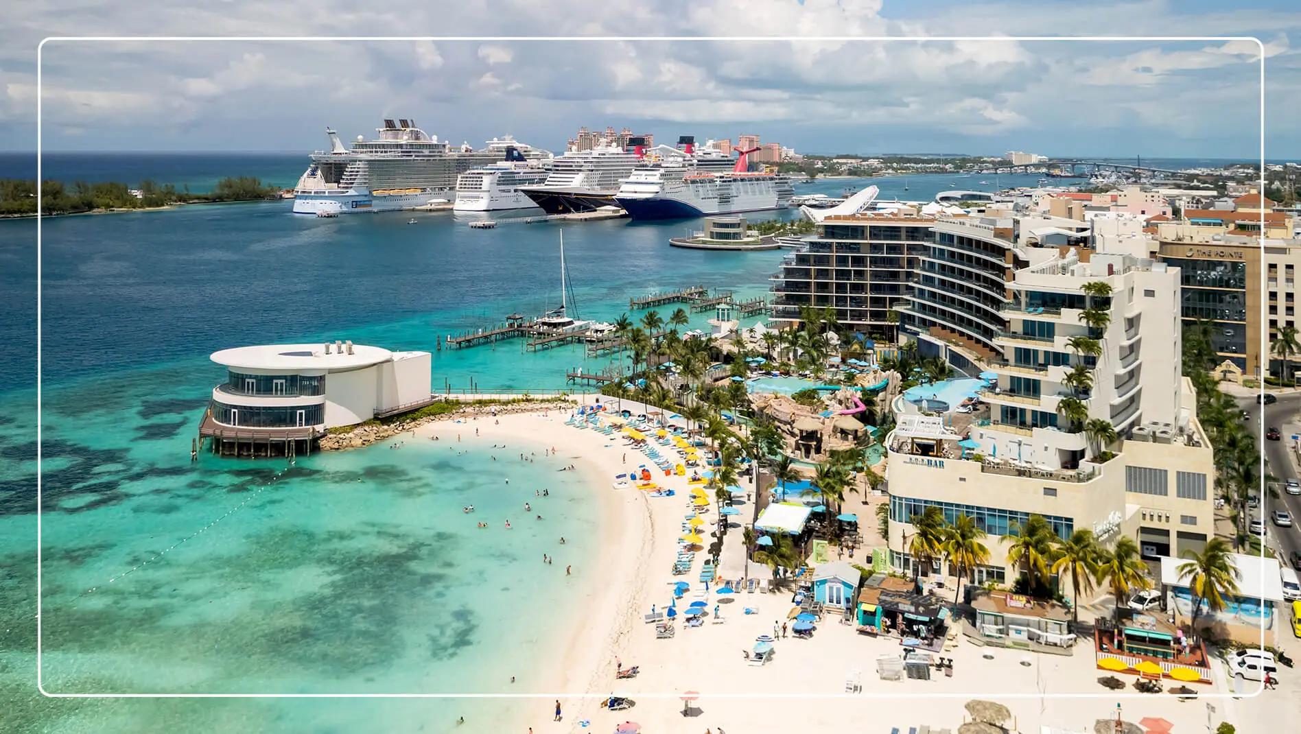An aerial view of the Margariteville Beach Resort Nassau with cruise ships in the background and the beach in the foreground.