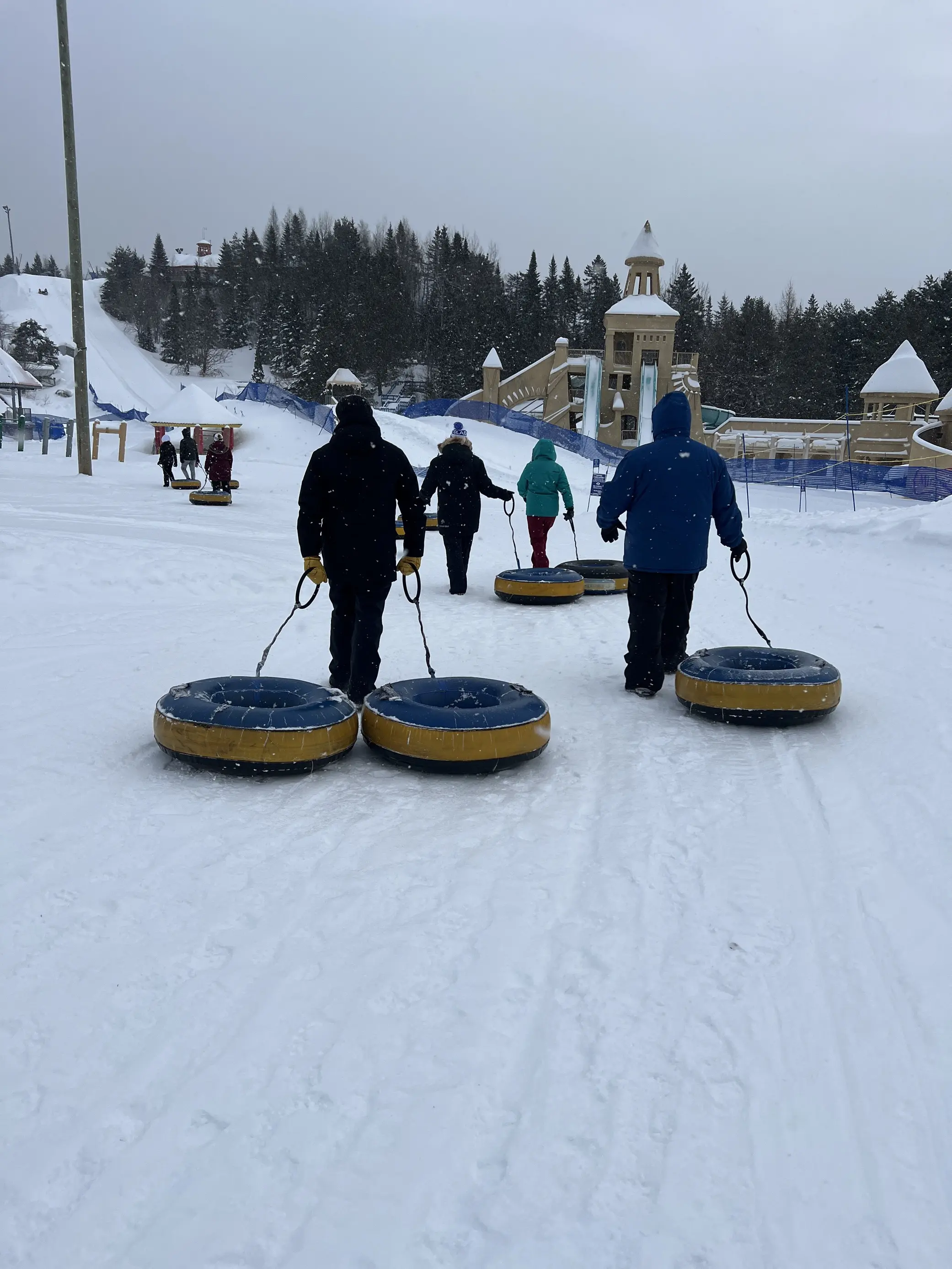 Outdoor image of people going tubing in the winter, with snowy weather.