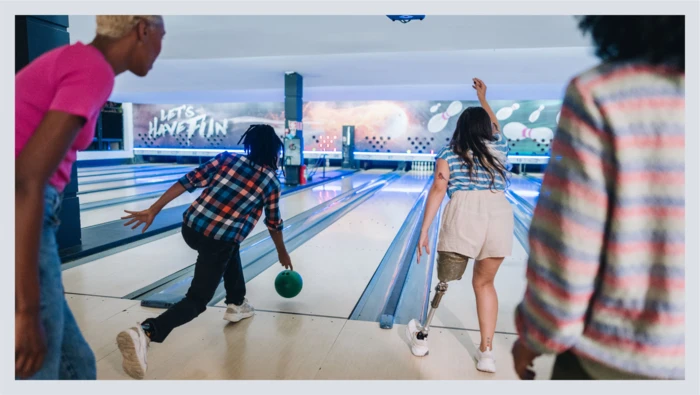 A family is shown bowling together at the bowling alley. 