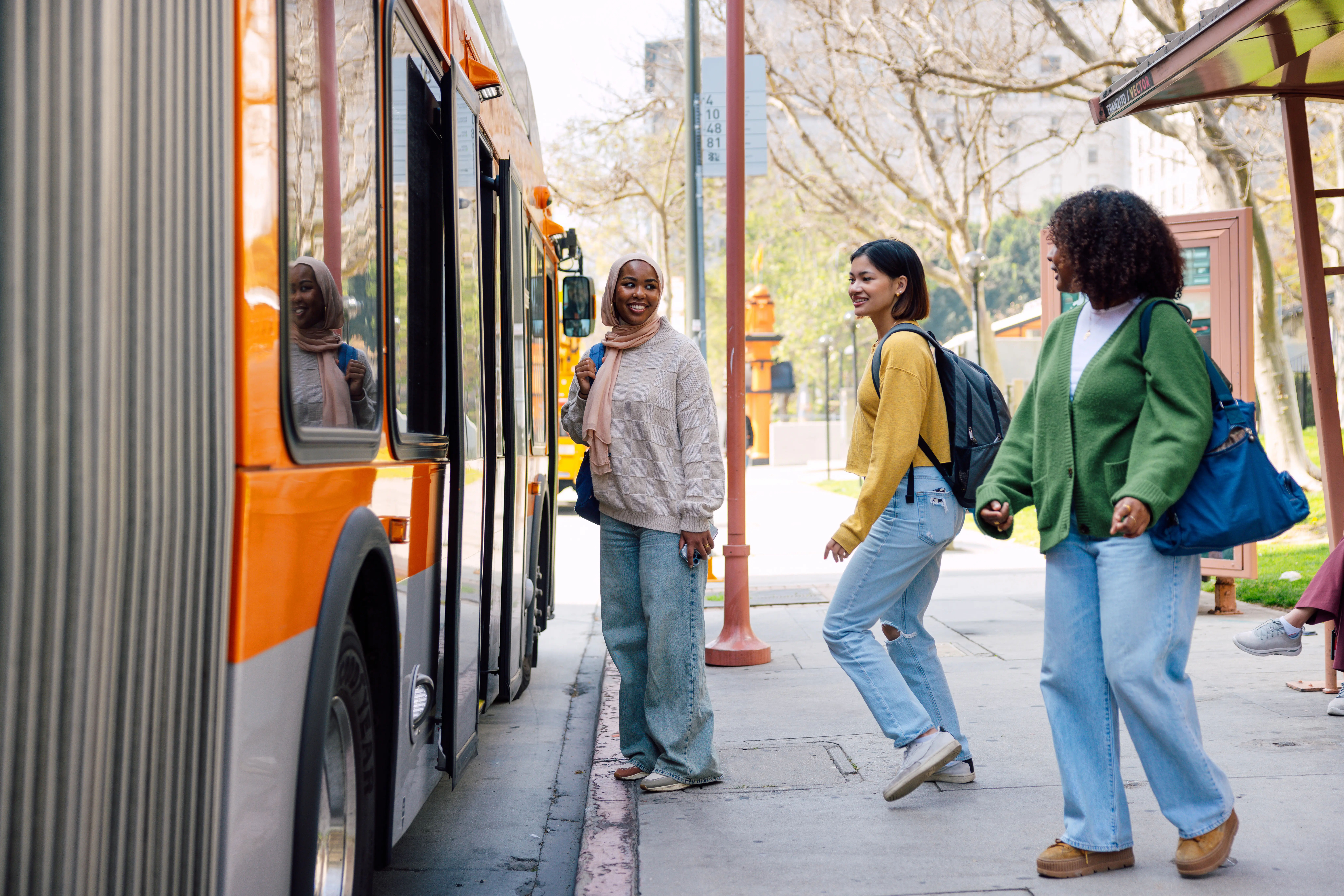 Three students waiting for the bus out of the University.