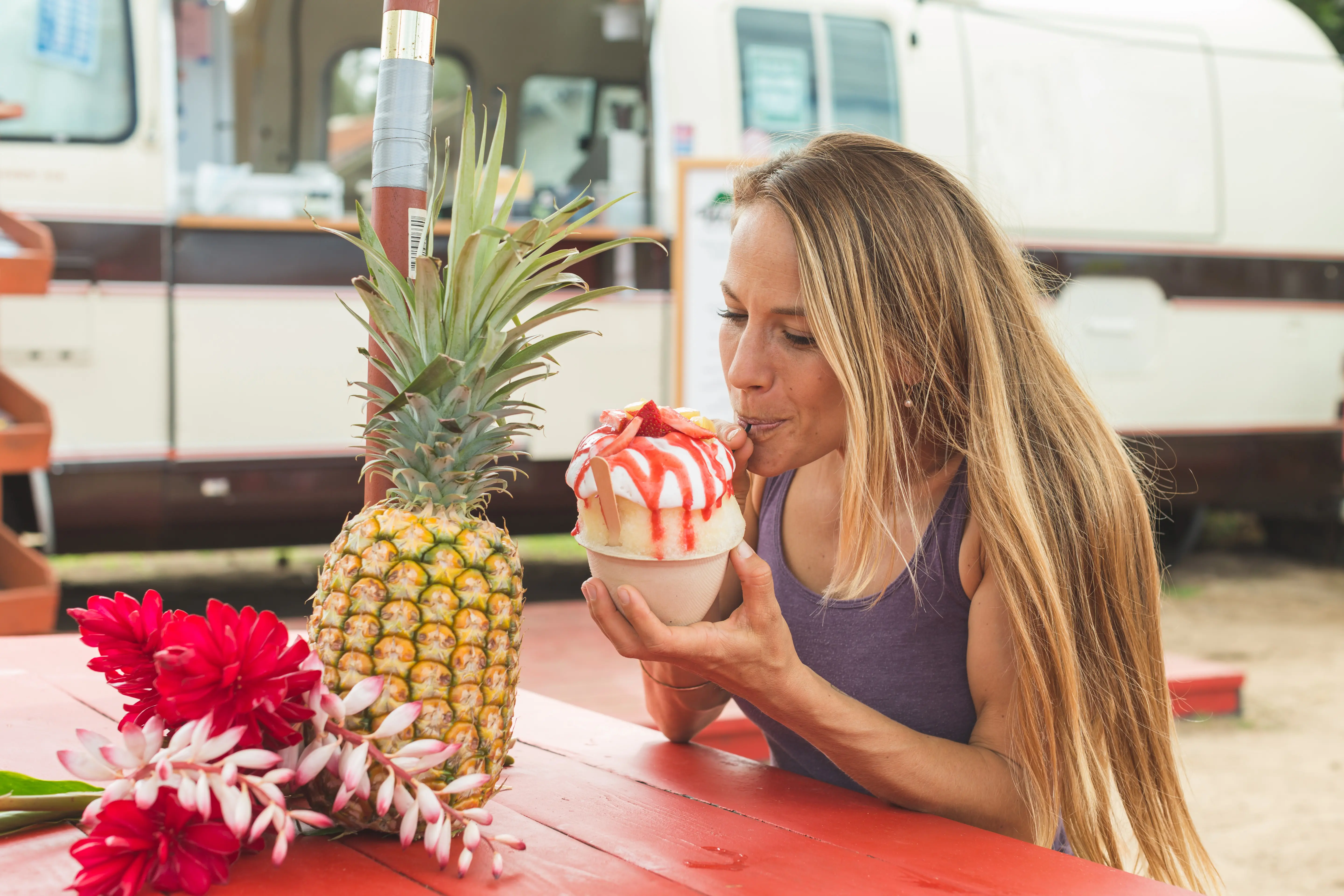 Image of a woman eating a Hawiian dessert treat.