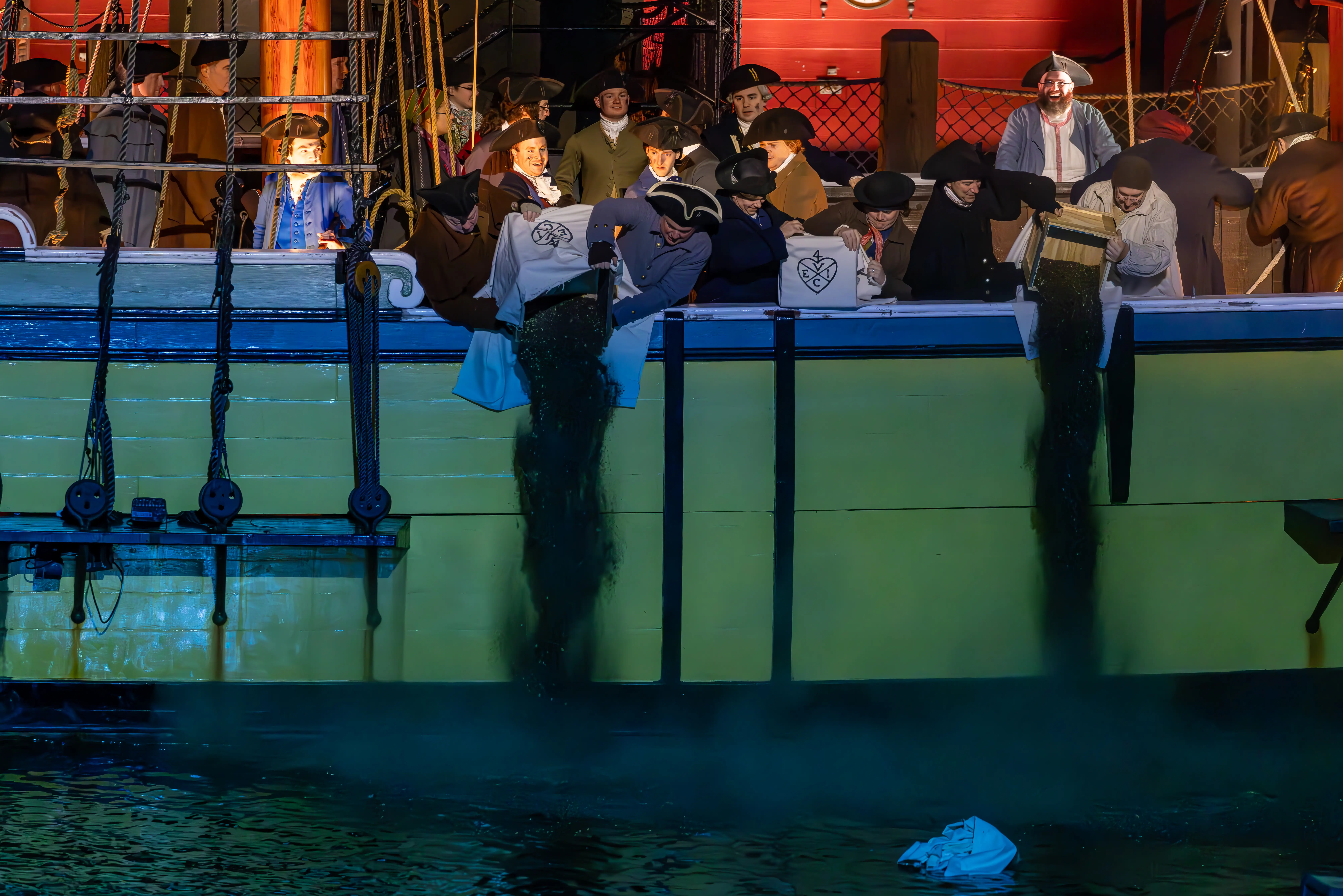 Image of a re-enactment of the famous Boston Tea Party dumping tea into the river.