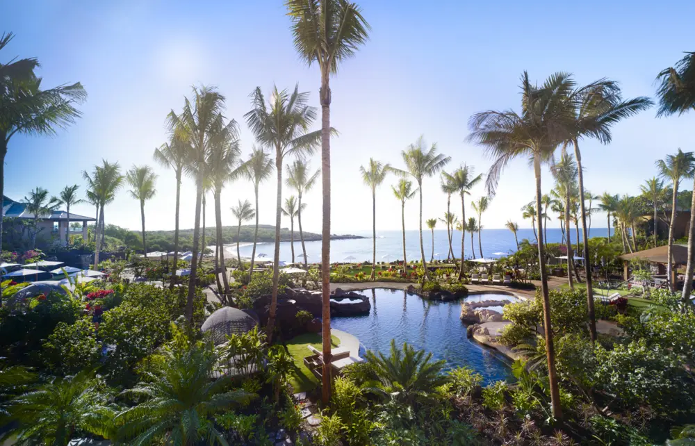 The resort provides panoramic ocean views atop rugged lava cliffs and white sand beaches.