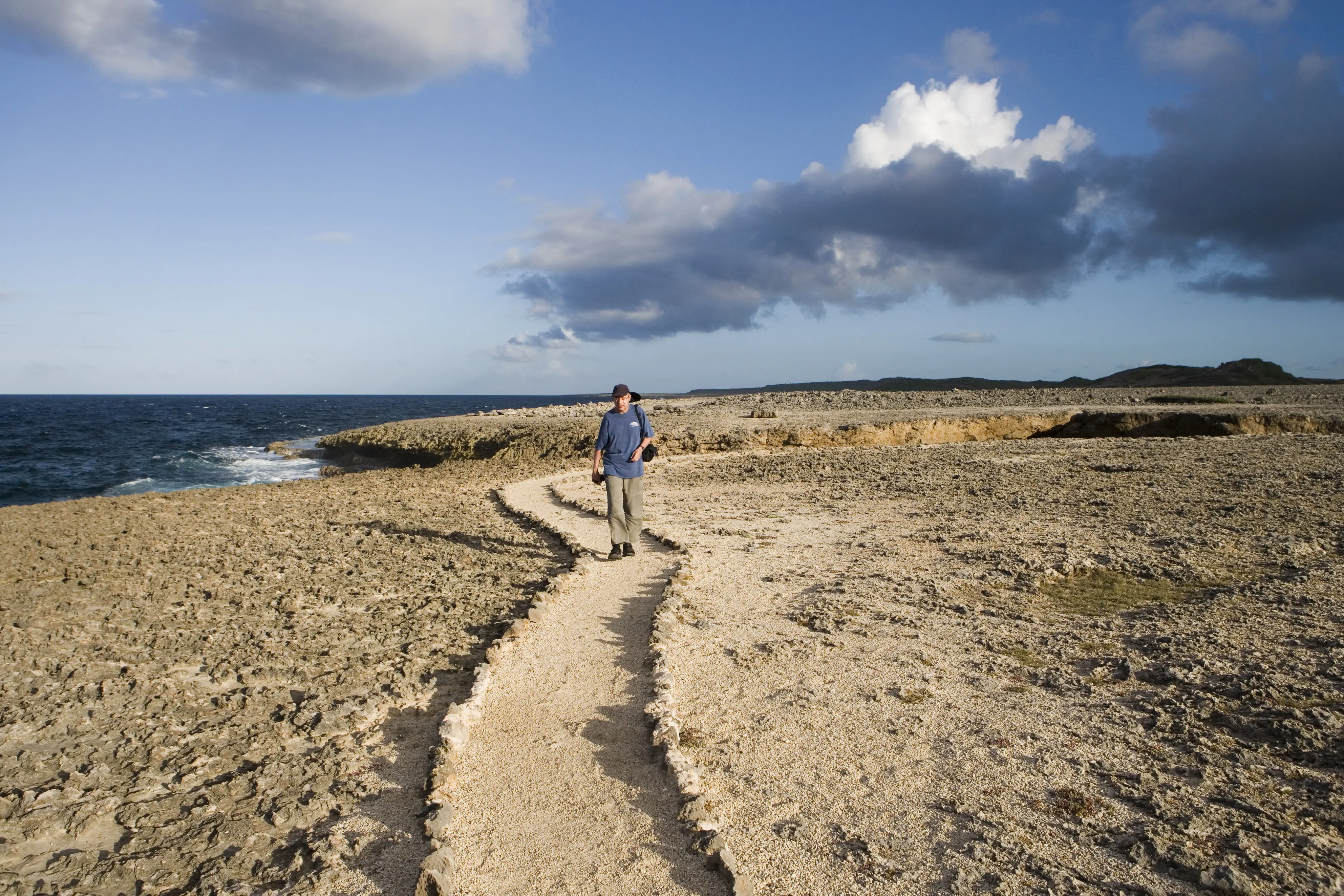 Image of a man walking at Boka Tabla in Shete Boka National Park.
