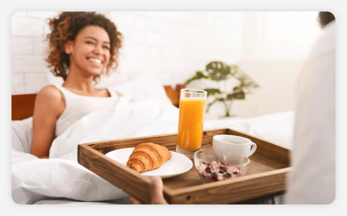 Someone surprising their partner to breakfast in bed 