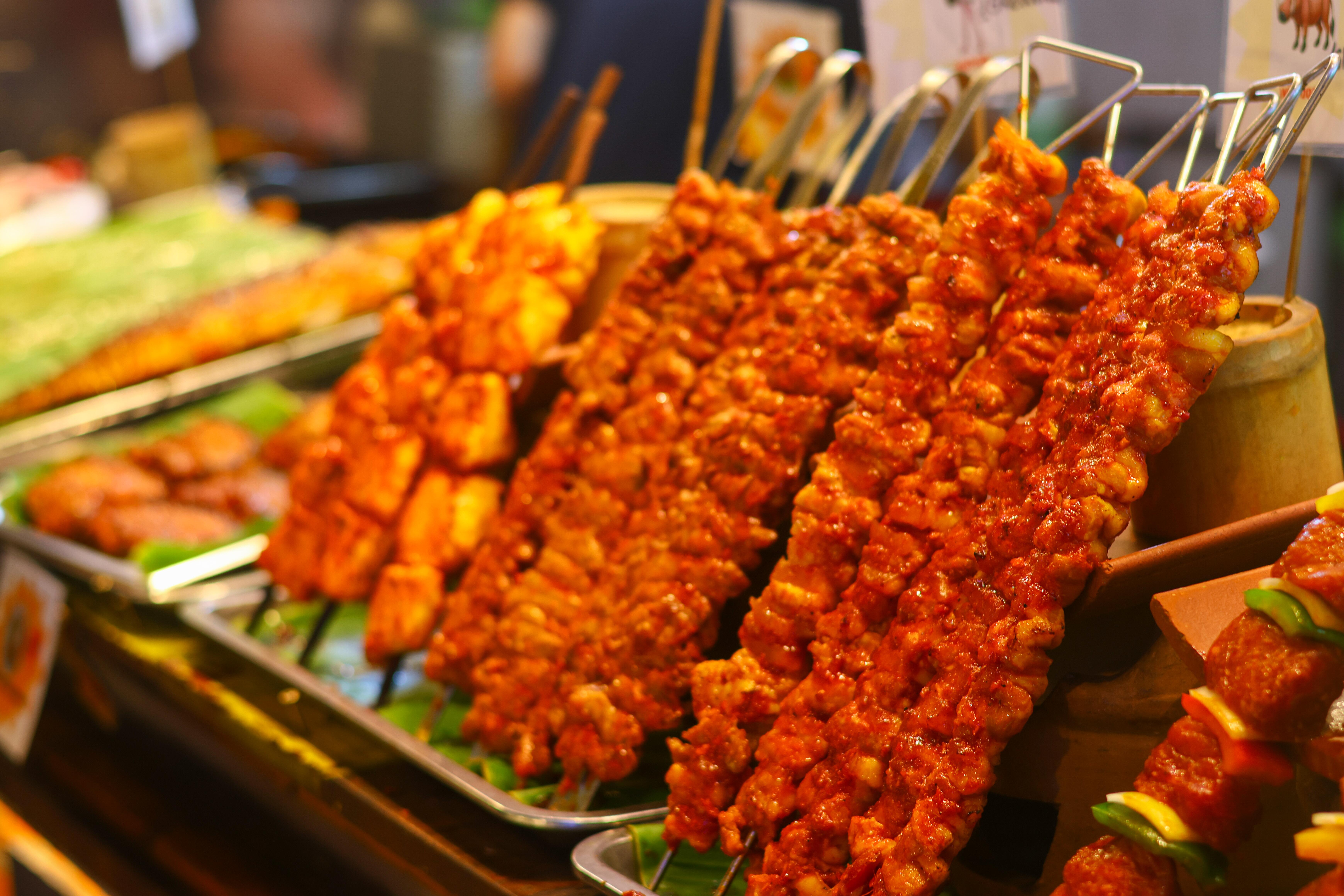 Image of various meat skewers at a buffet.
