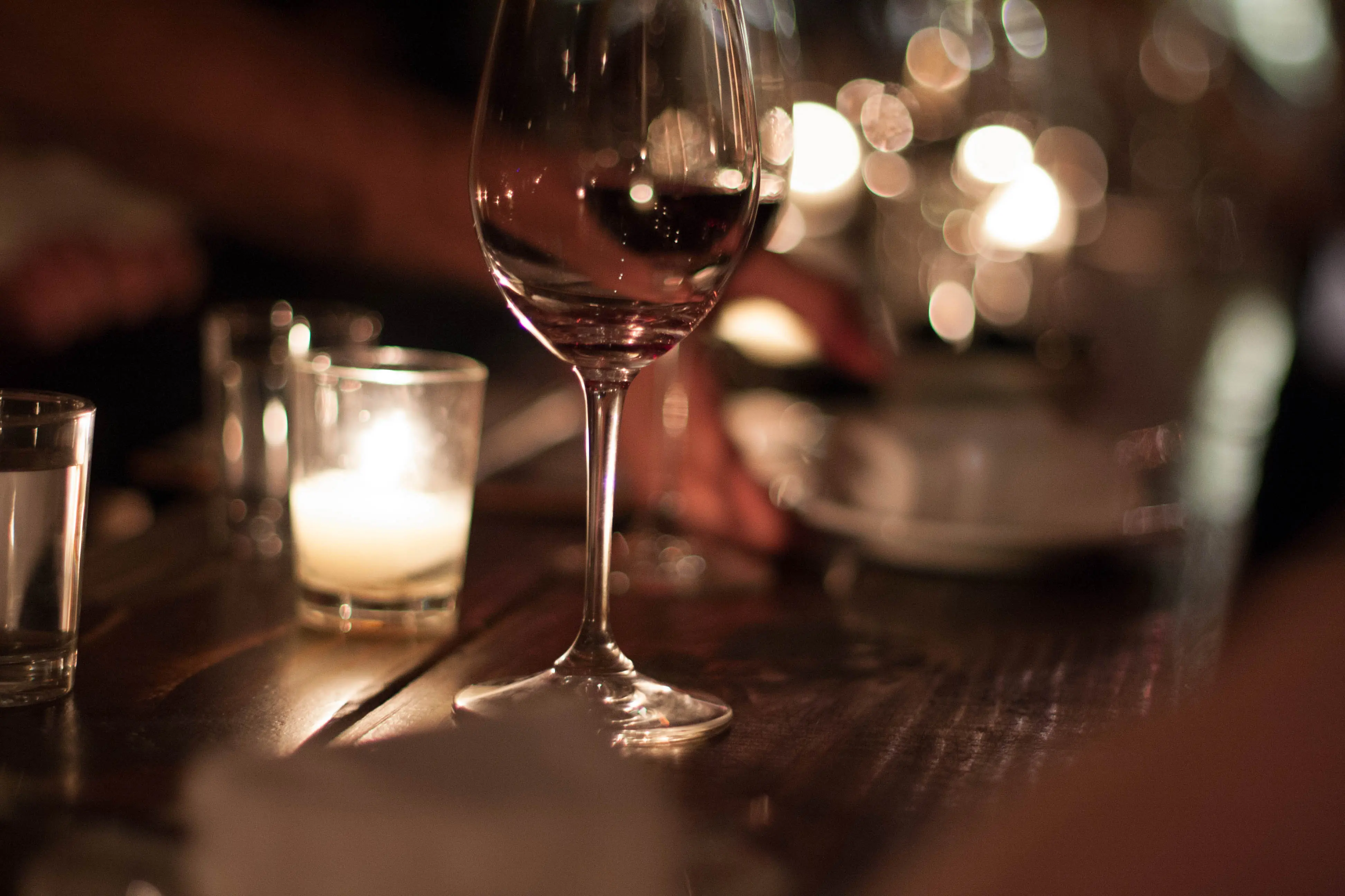 Closeup image of a wine glass sitting on a bar countertop.