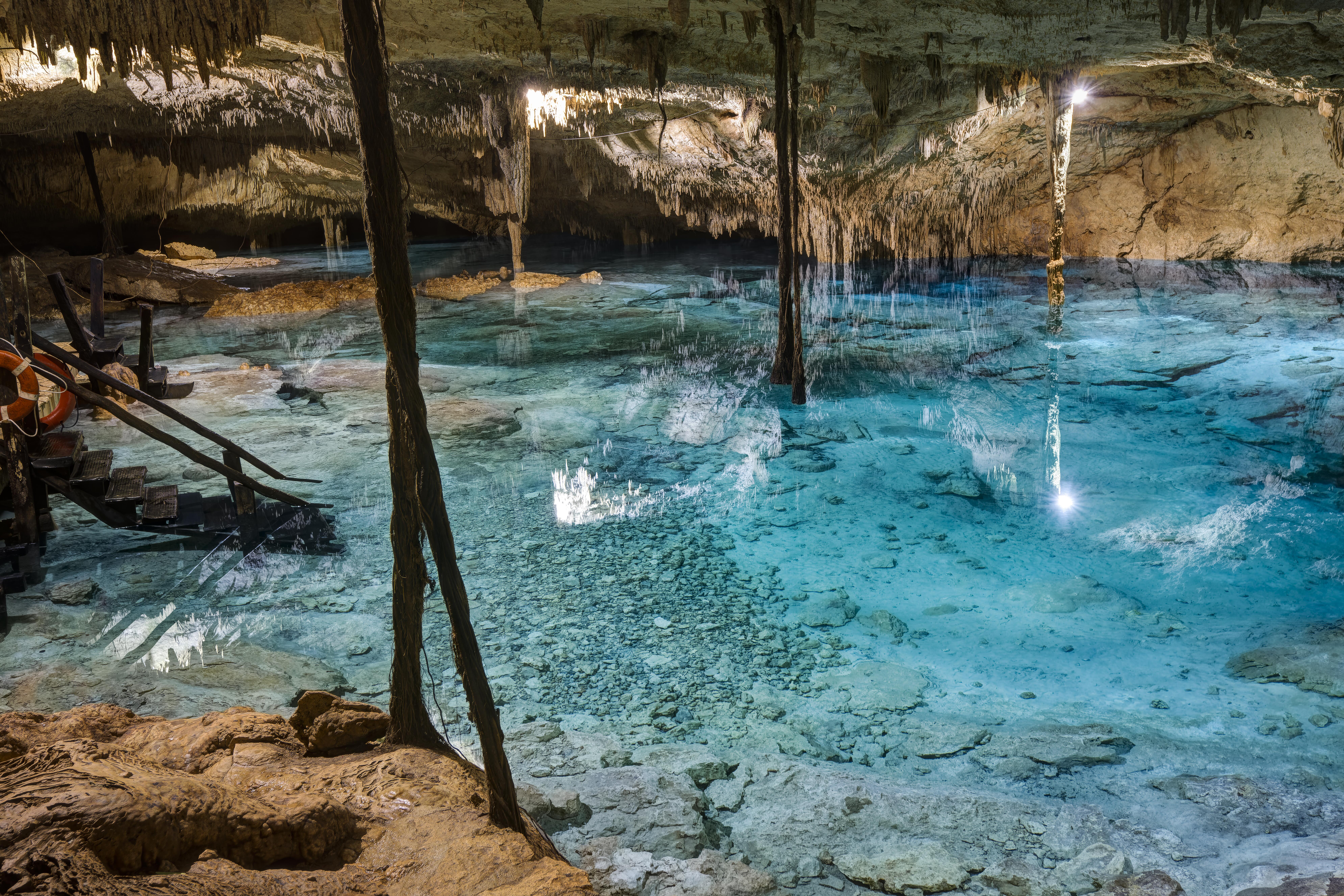 Taakk Bi Ha Cenote, an underground cave sinkhole with bright blue water in Riviera Maya, Playa del Carmen, Mexico