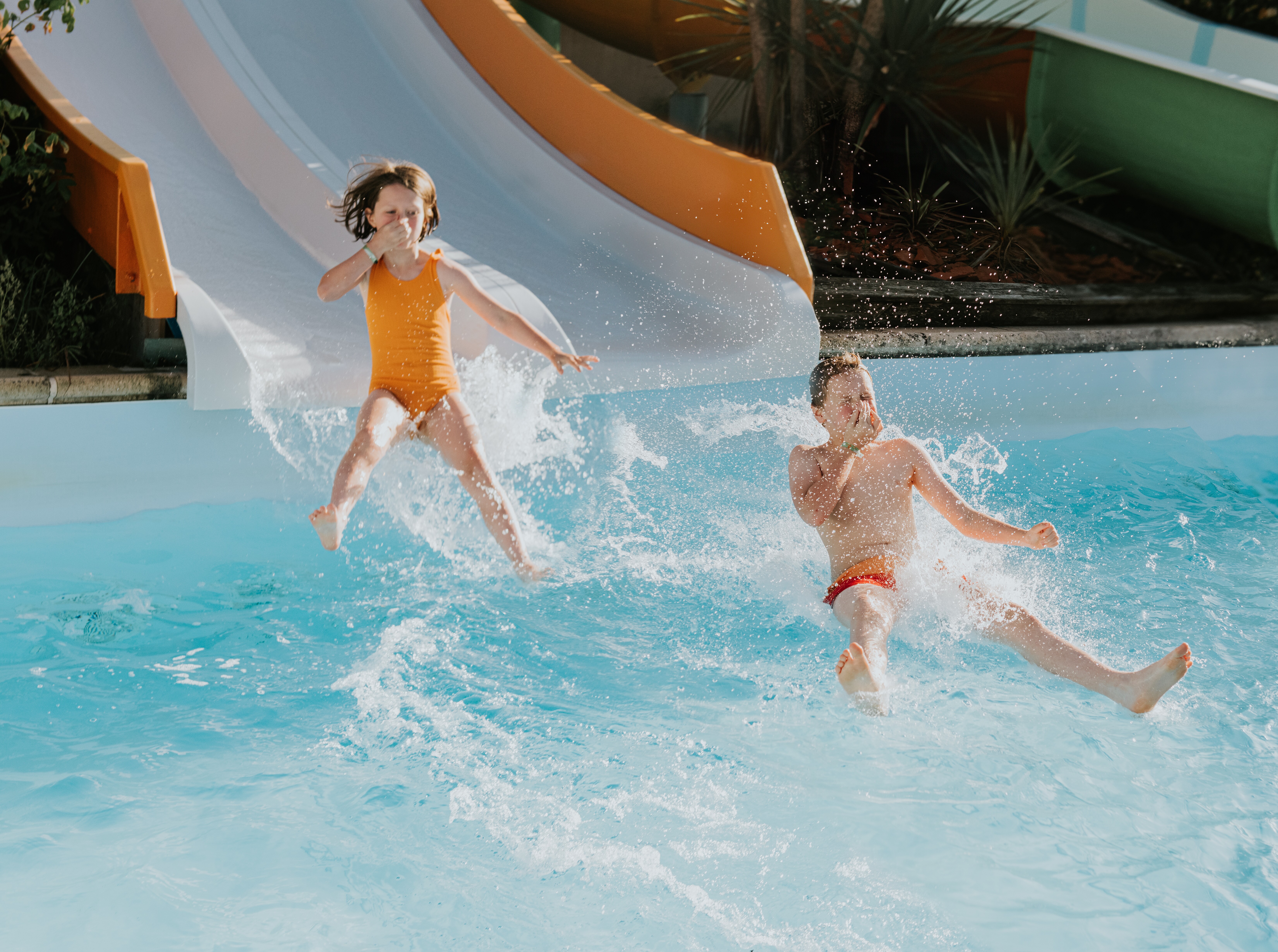 Image of two kids going down a water slide.