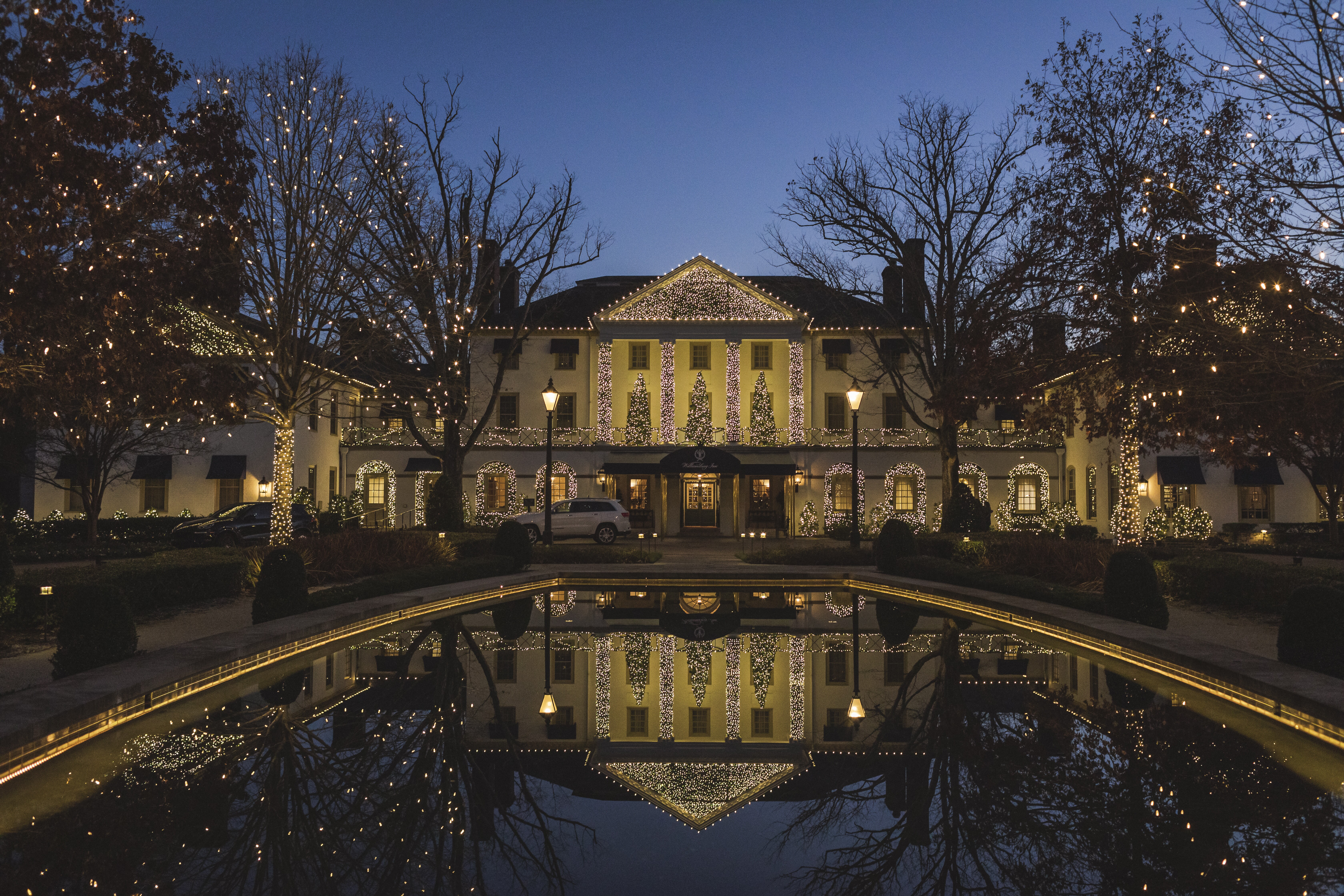 exterior of white hotel lit with white string lights