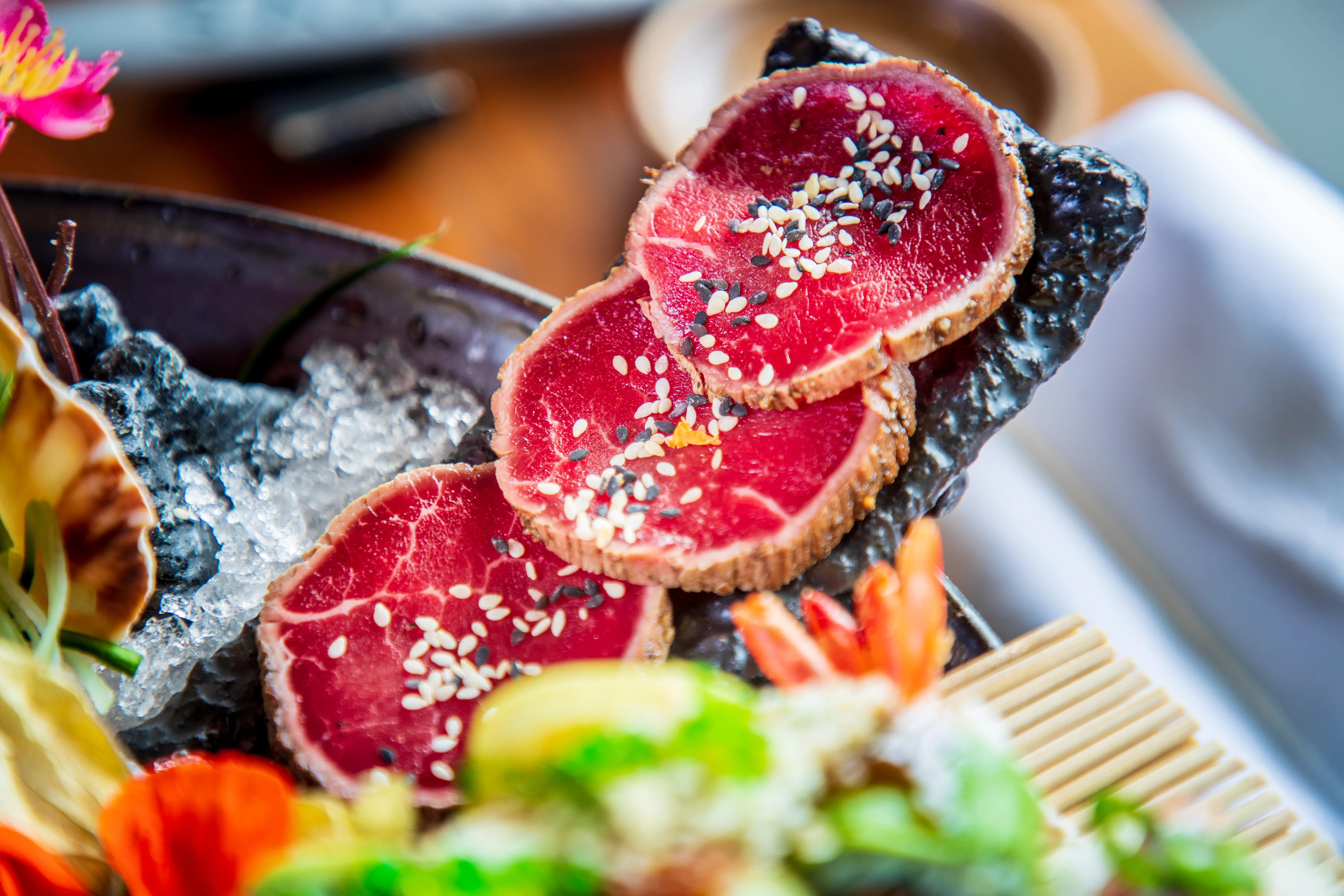 Seared, thinly sliced wagyu beef and seasoned with black and white sesame served on ice