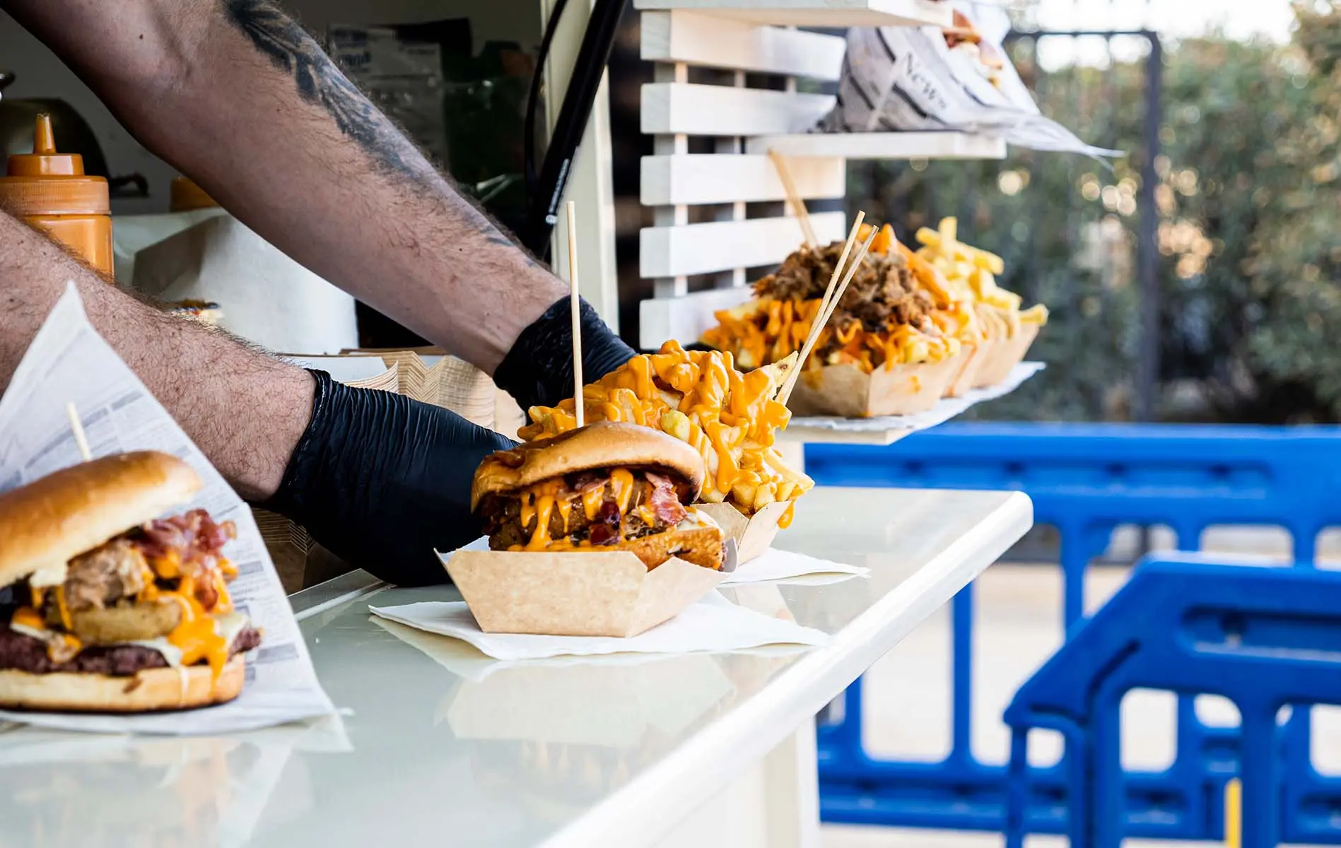A food cart worker handing out burger orders