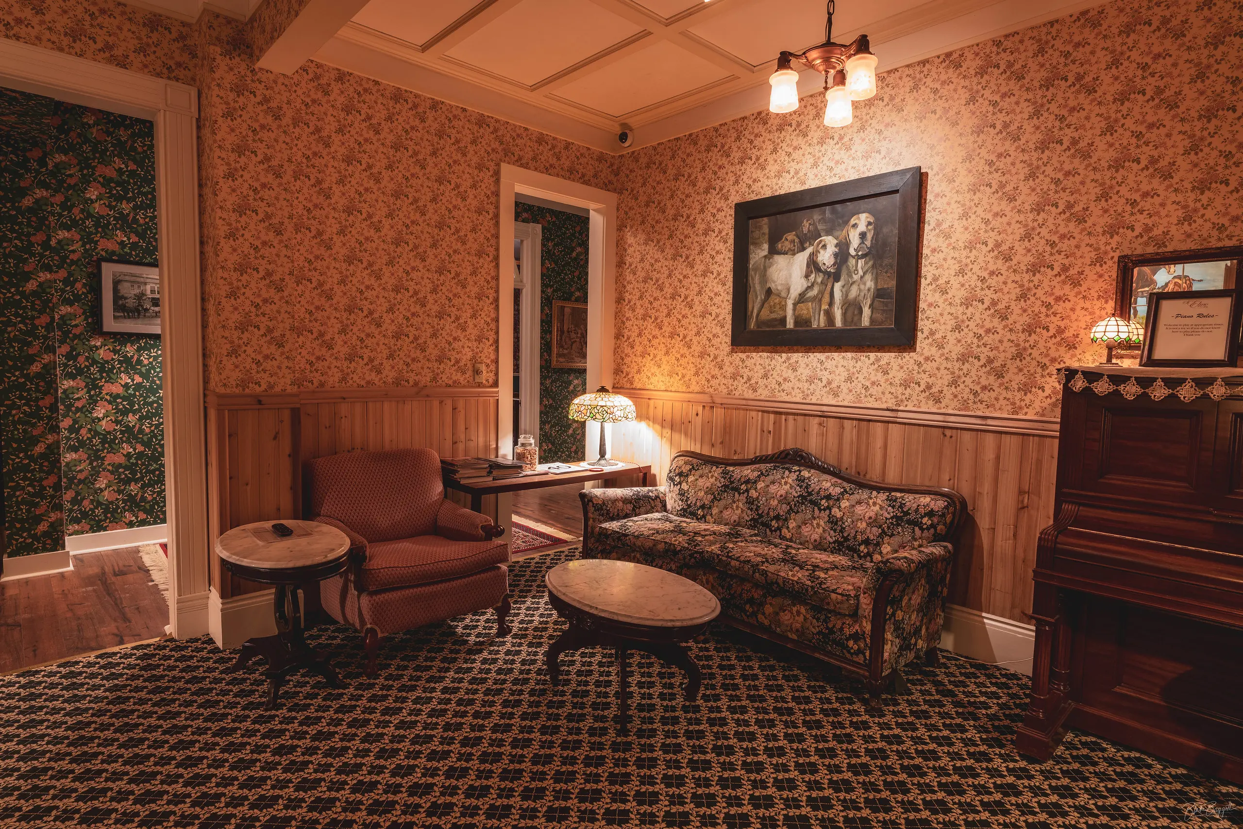 A sitting room decorated with floral wallpaper and patterned carpeting at the St. Elmo Hotel in Ouray, Colorado.