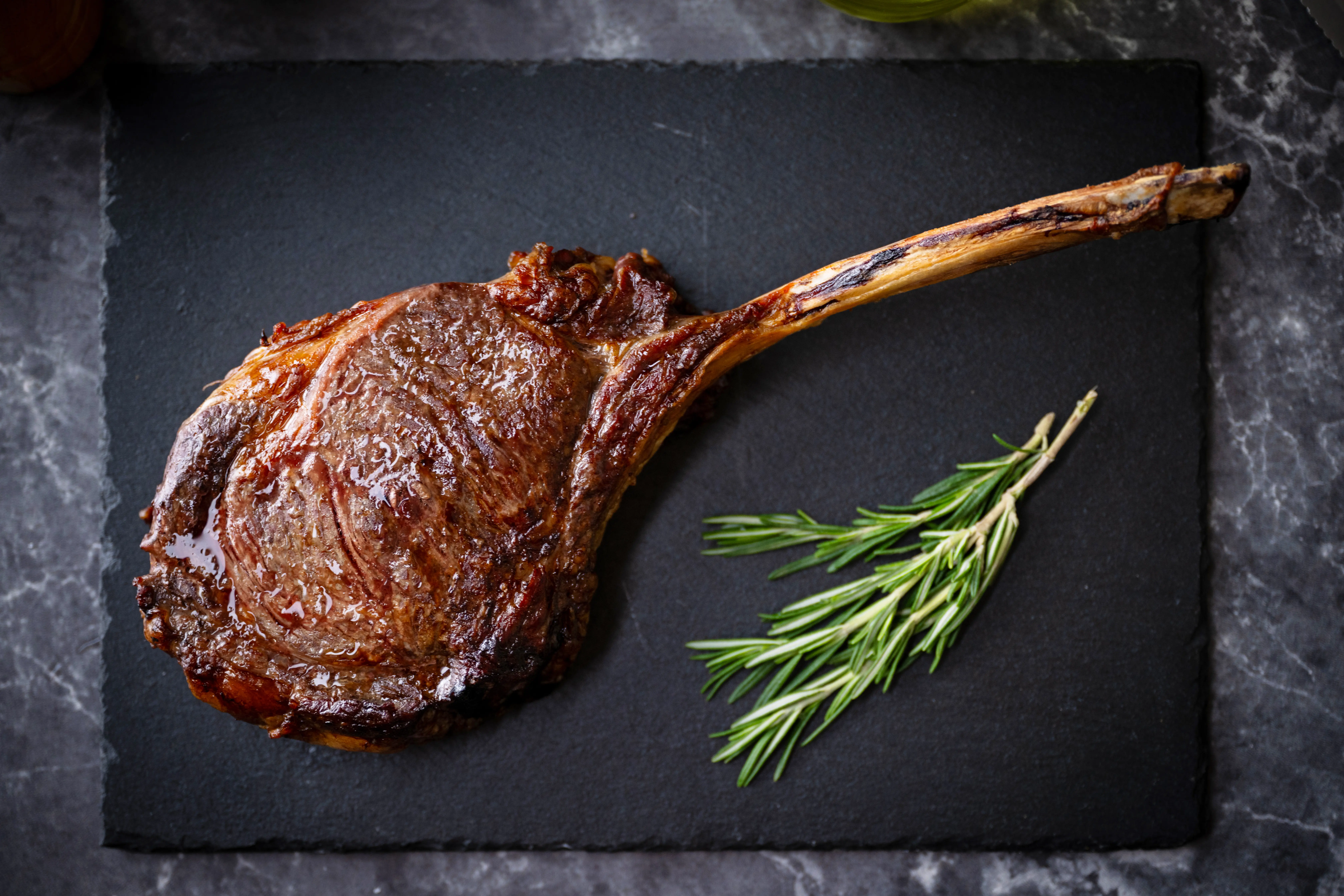 Seared Tomahawk steak with rosemary sprig