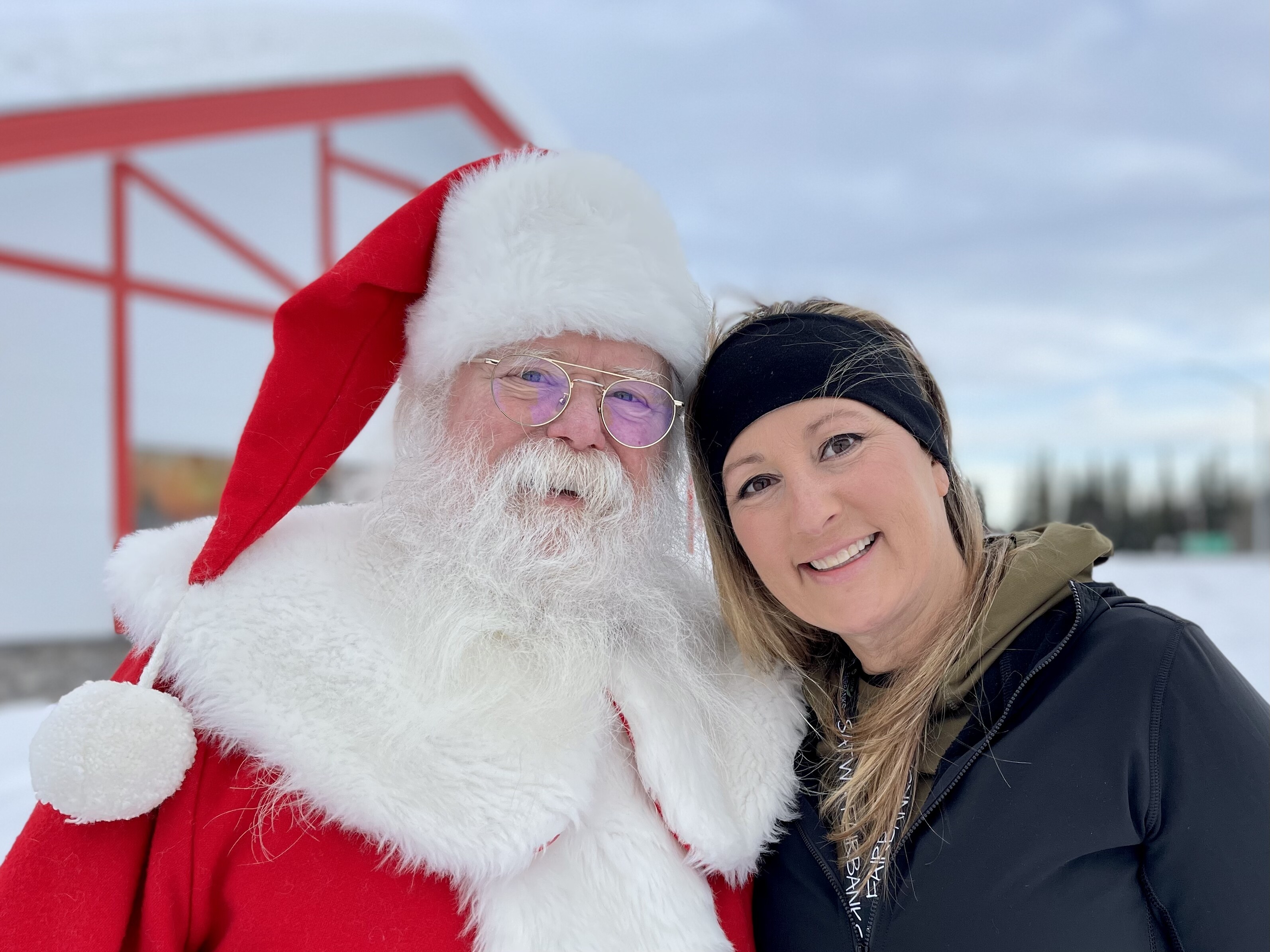 Santa Claus and Jennifer Broome standing in the snow