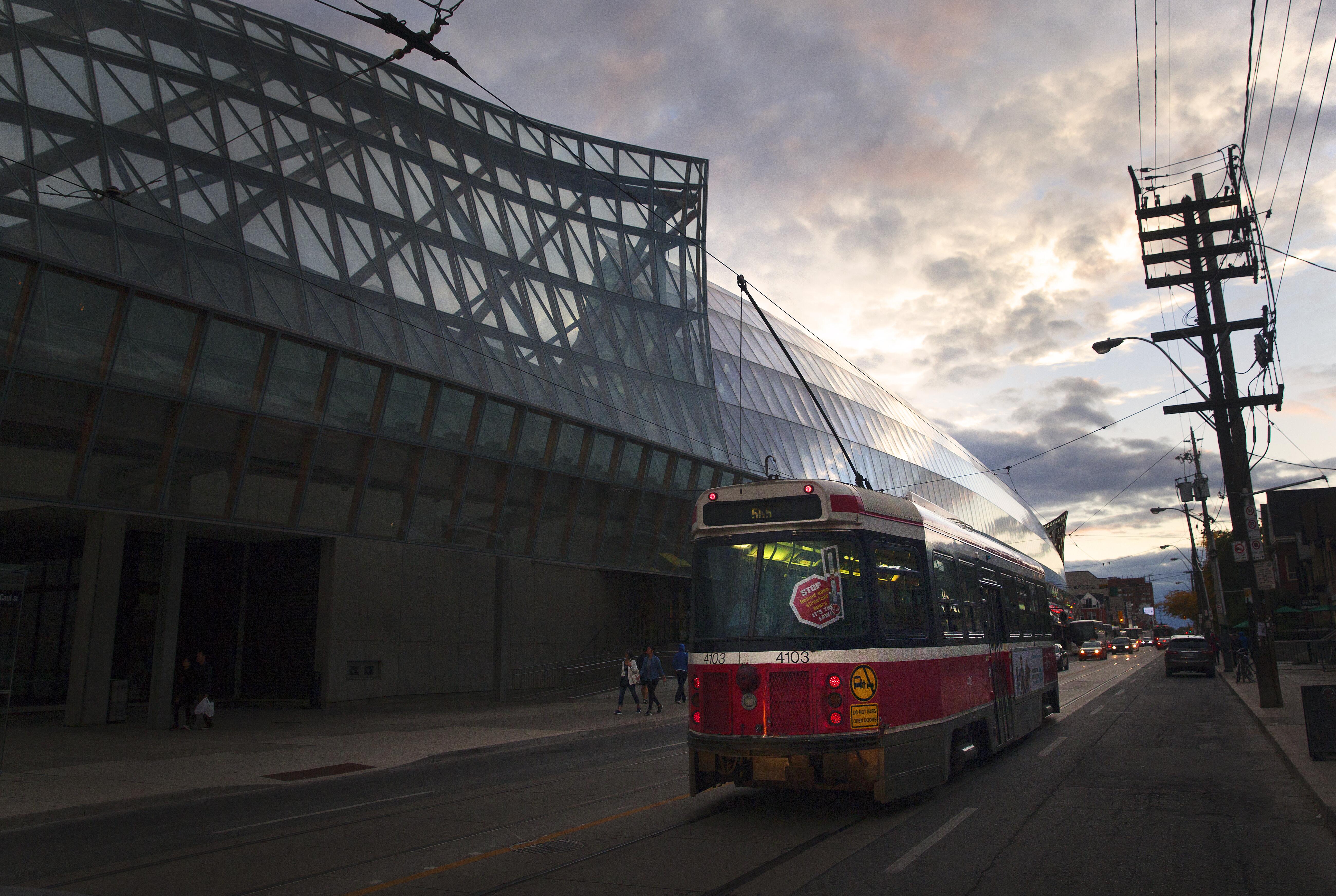 Exterior image of the Art Gallery of Ontario, with a trolley car going by.