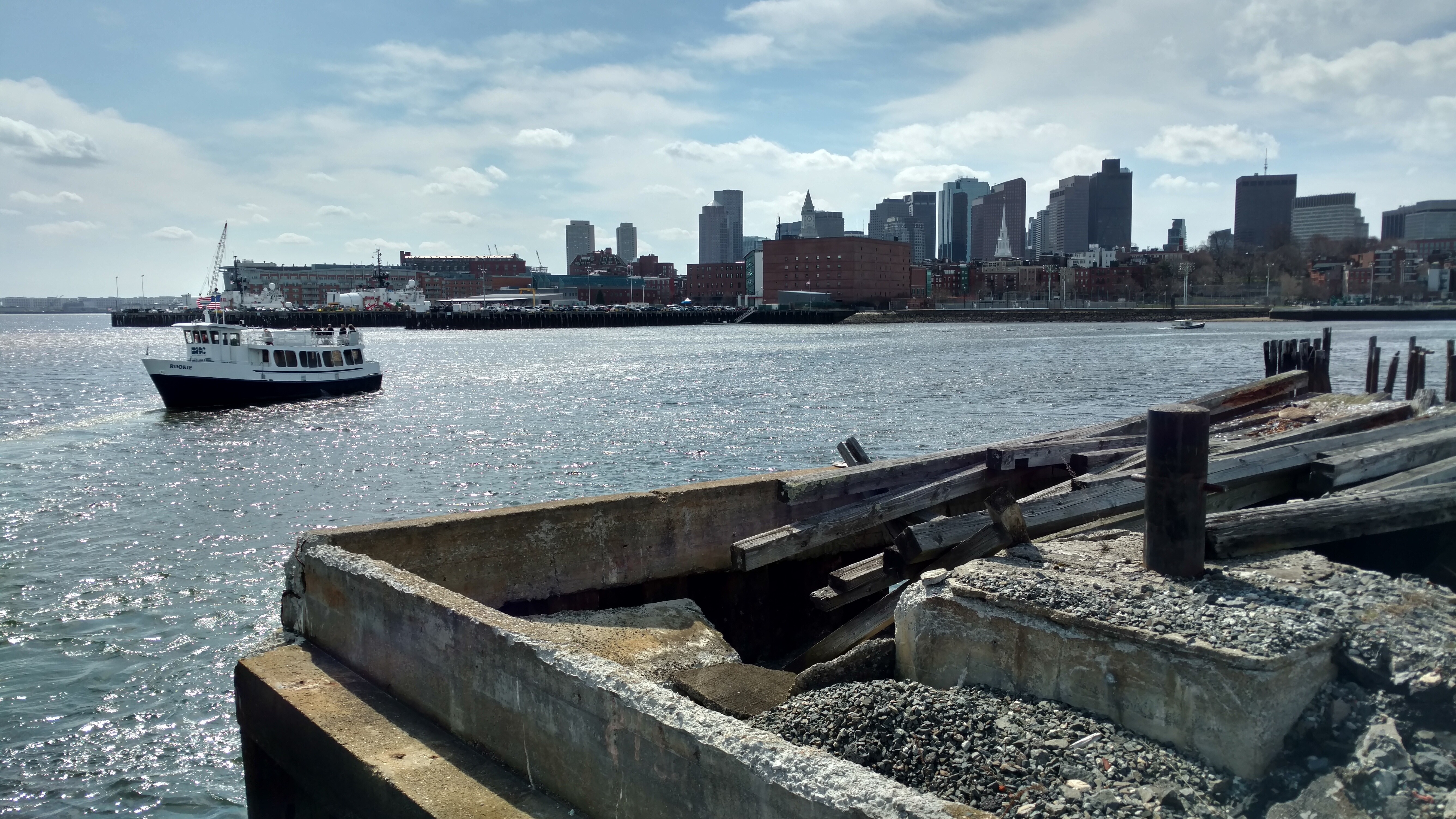 Image of a Boston Harbor Ferry with the city skyline in the background.