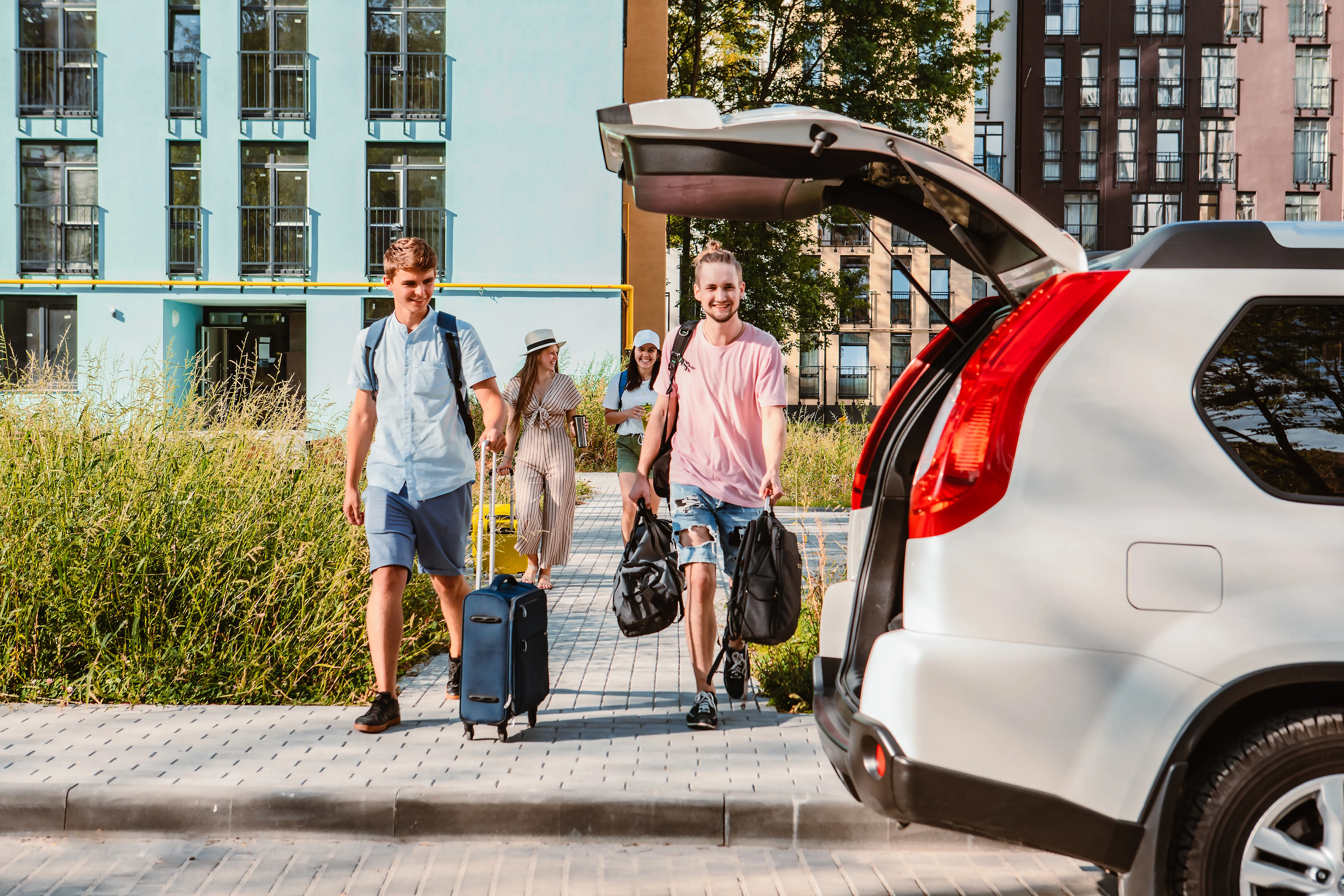 friends load car trunk with baggage