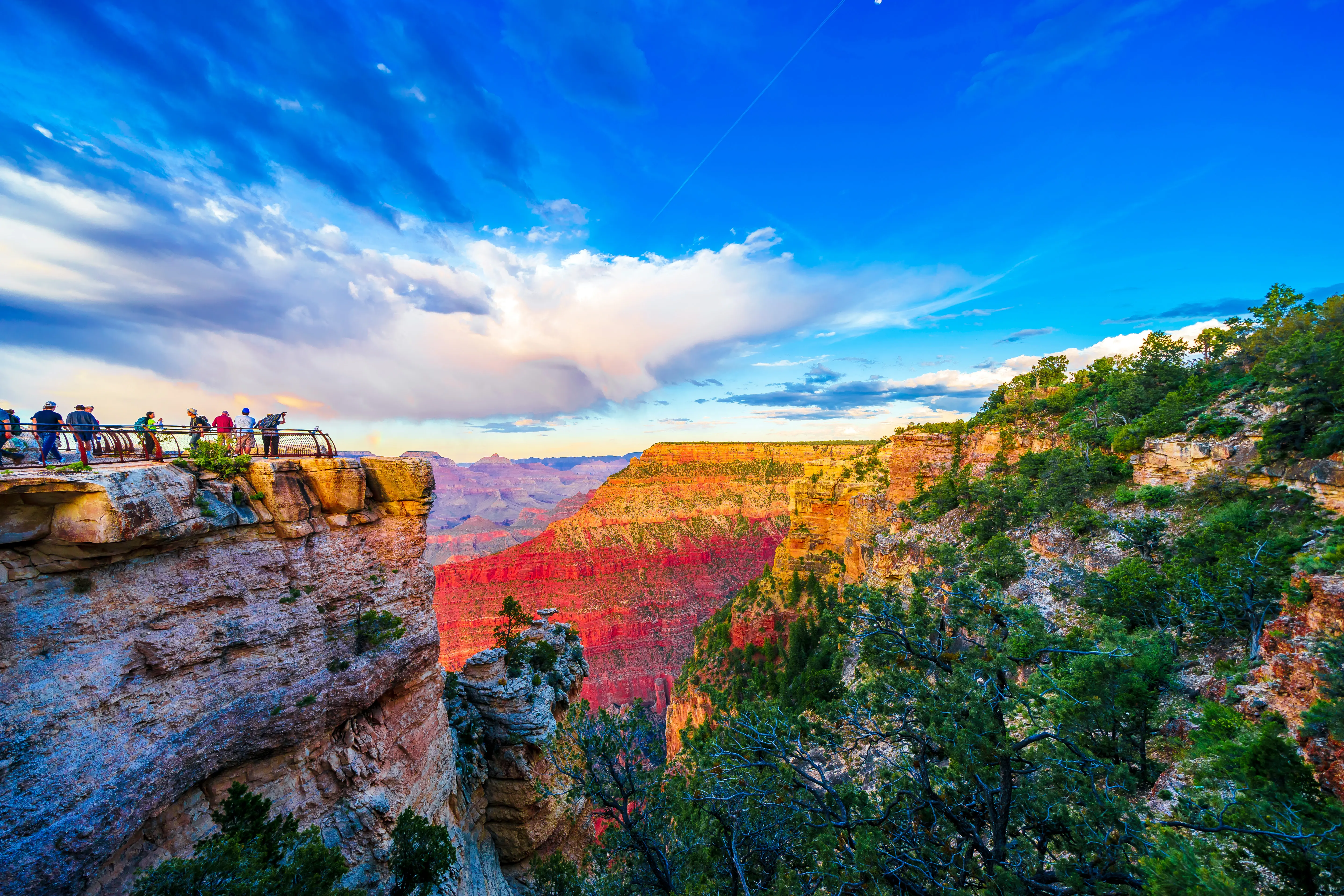 Panoramic image over the canyons with the colorful sunset and tourists gathered at Mather Point lookout in Grand Canyon National Park South Rim, Arizona, USA