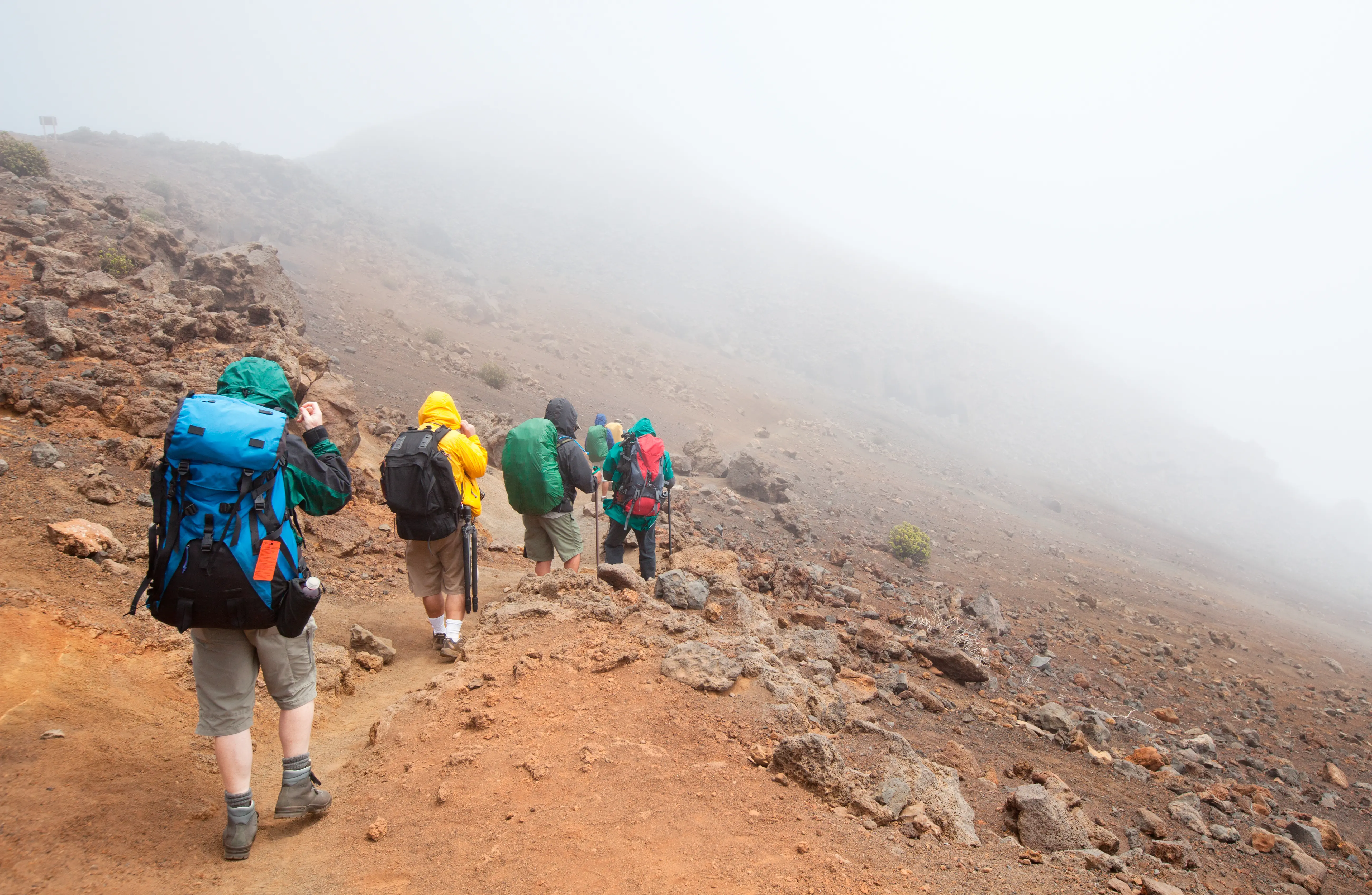 Image of a small group of people wih backpacks hiking at Haleakala National Park, dormant volcano on top of east Maui, Hawaii.
