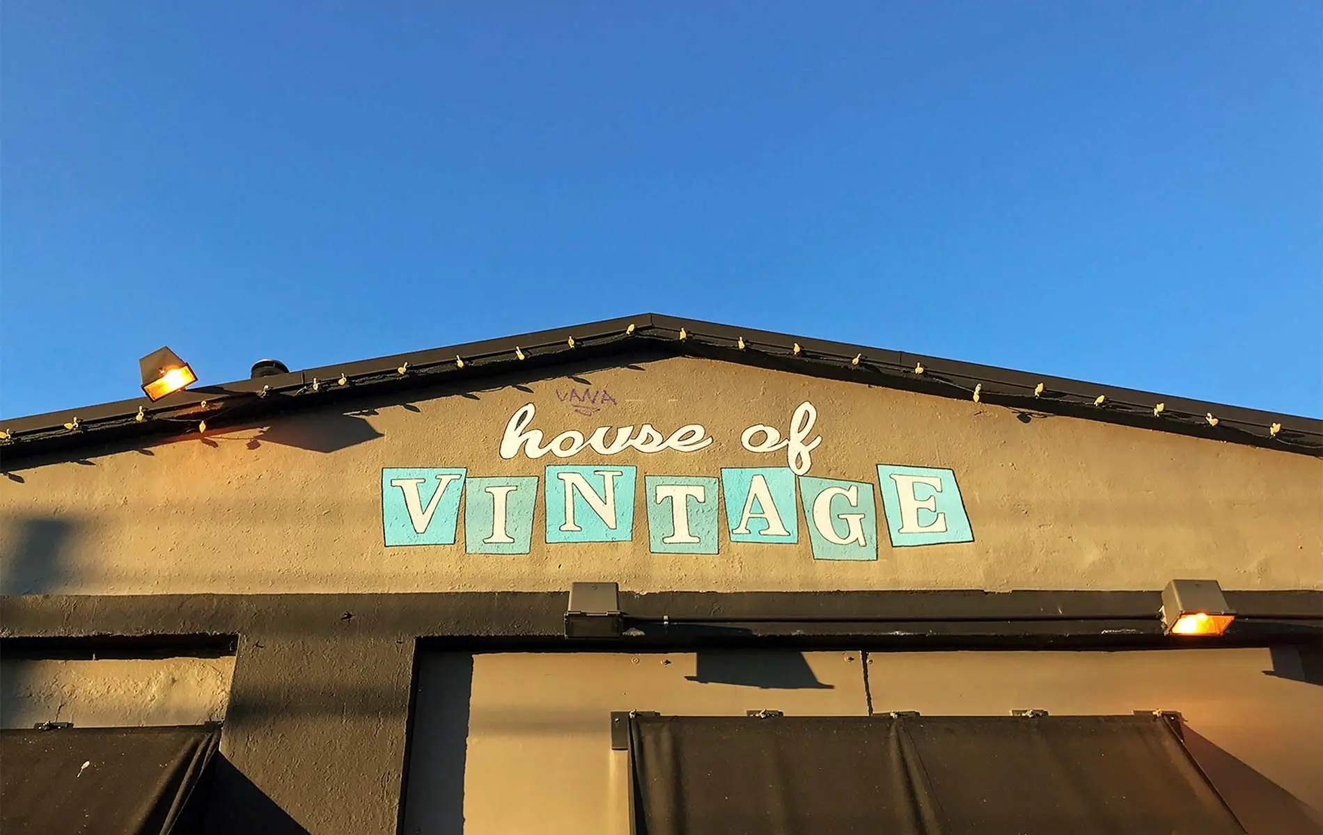 A shot of a store sign titled “House of Vintage” painted on a building.