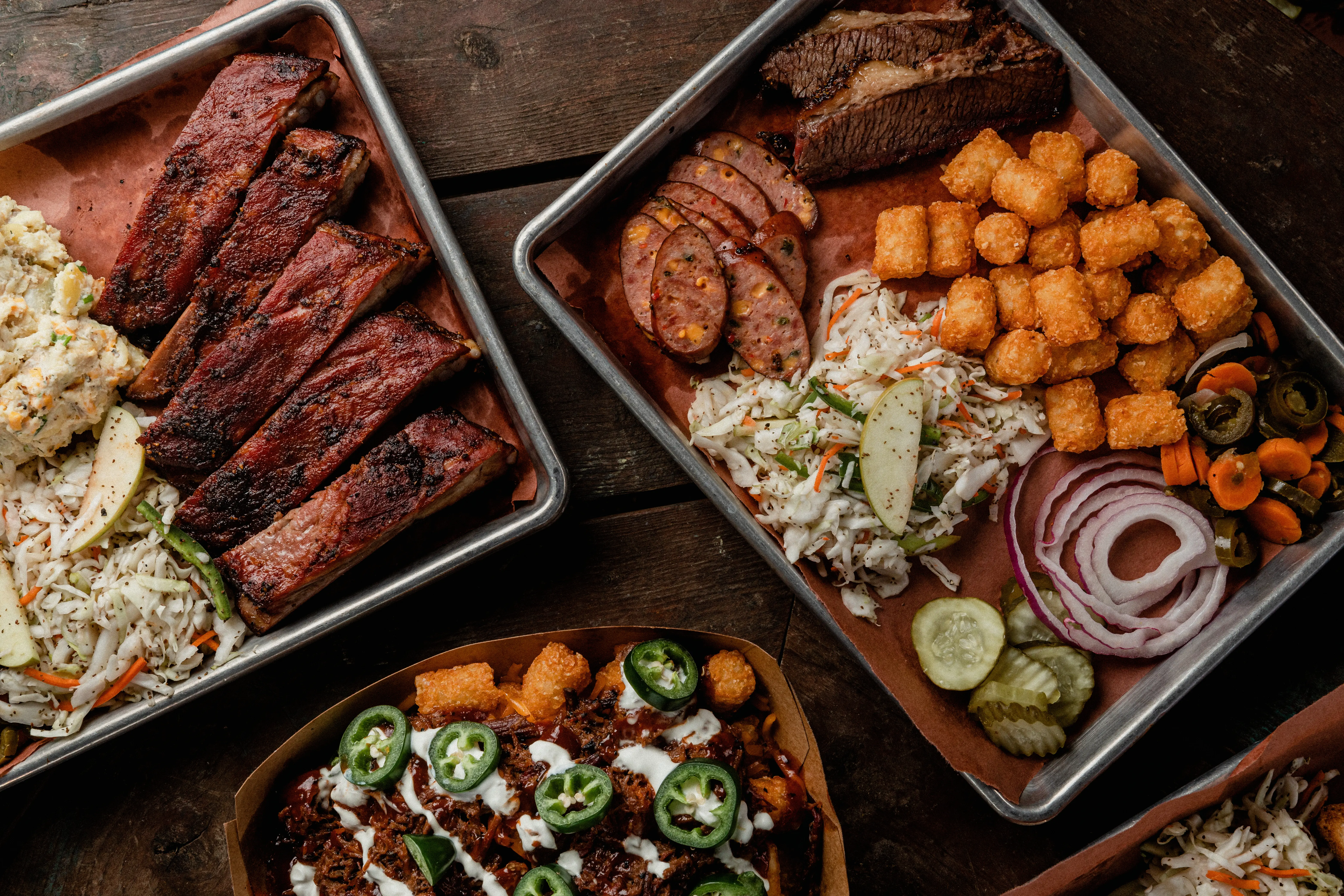 Image of several platters and dishes of classic Texas barbecue.