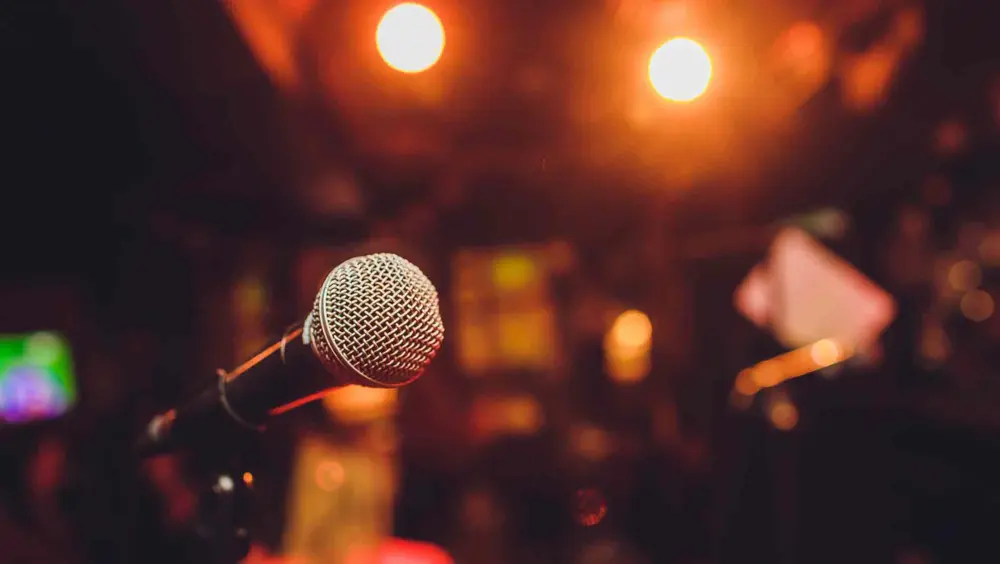 A mic at Second City Comedy Club with stage lights in the background.