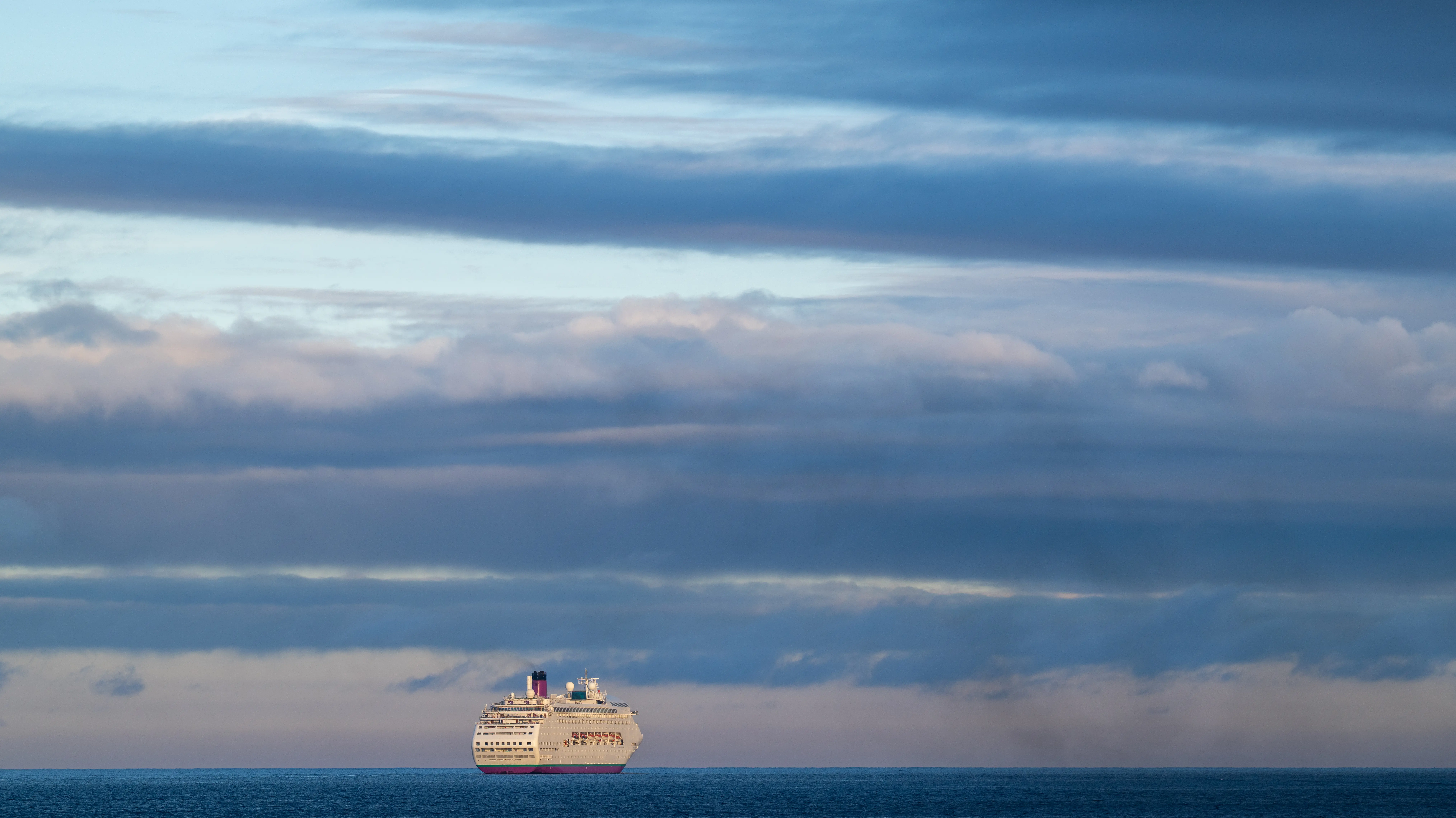 Image of a cruise ship sailing on the open ocean.