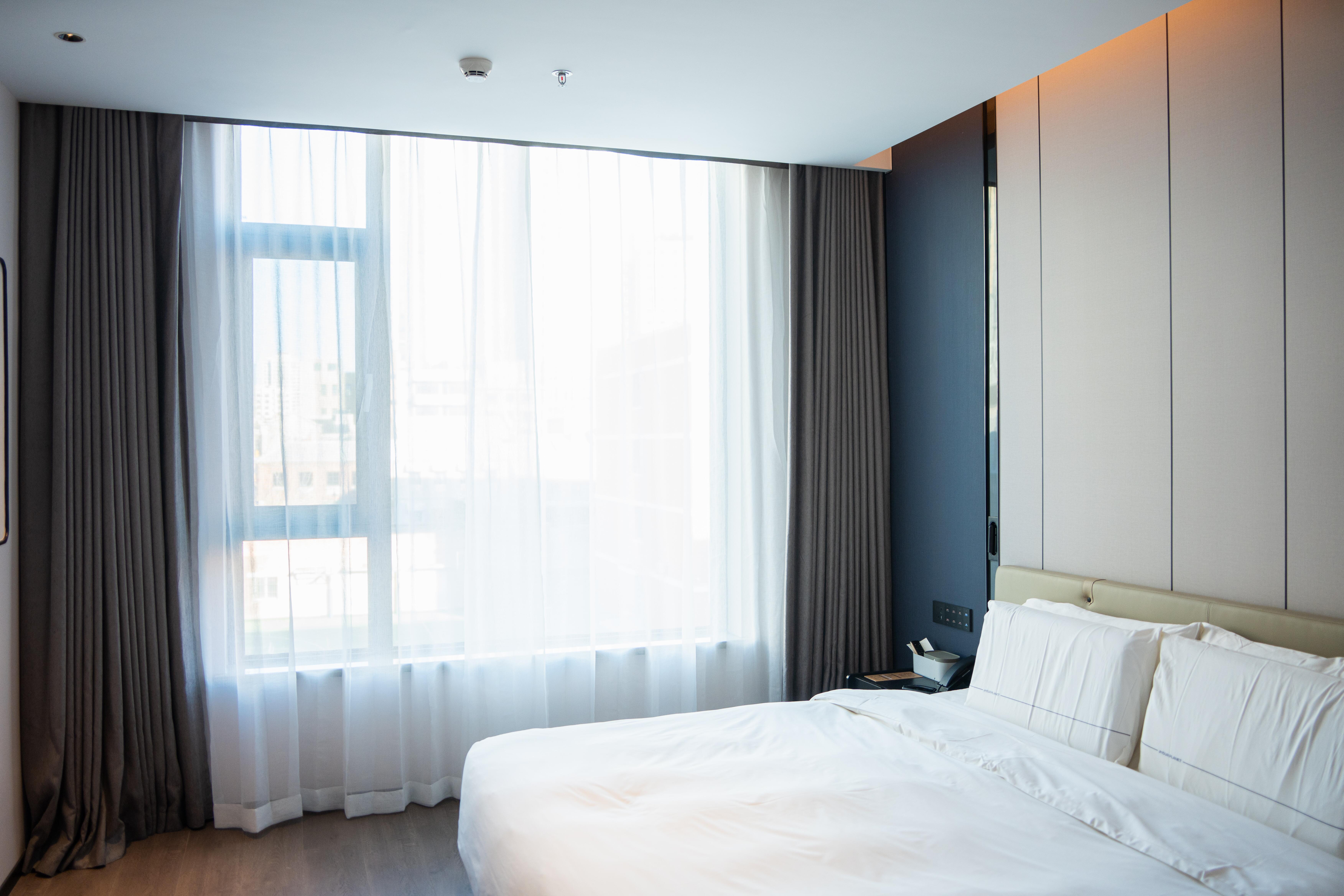 Image of a sleek hotel room with sunlight coming through the window.