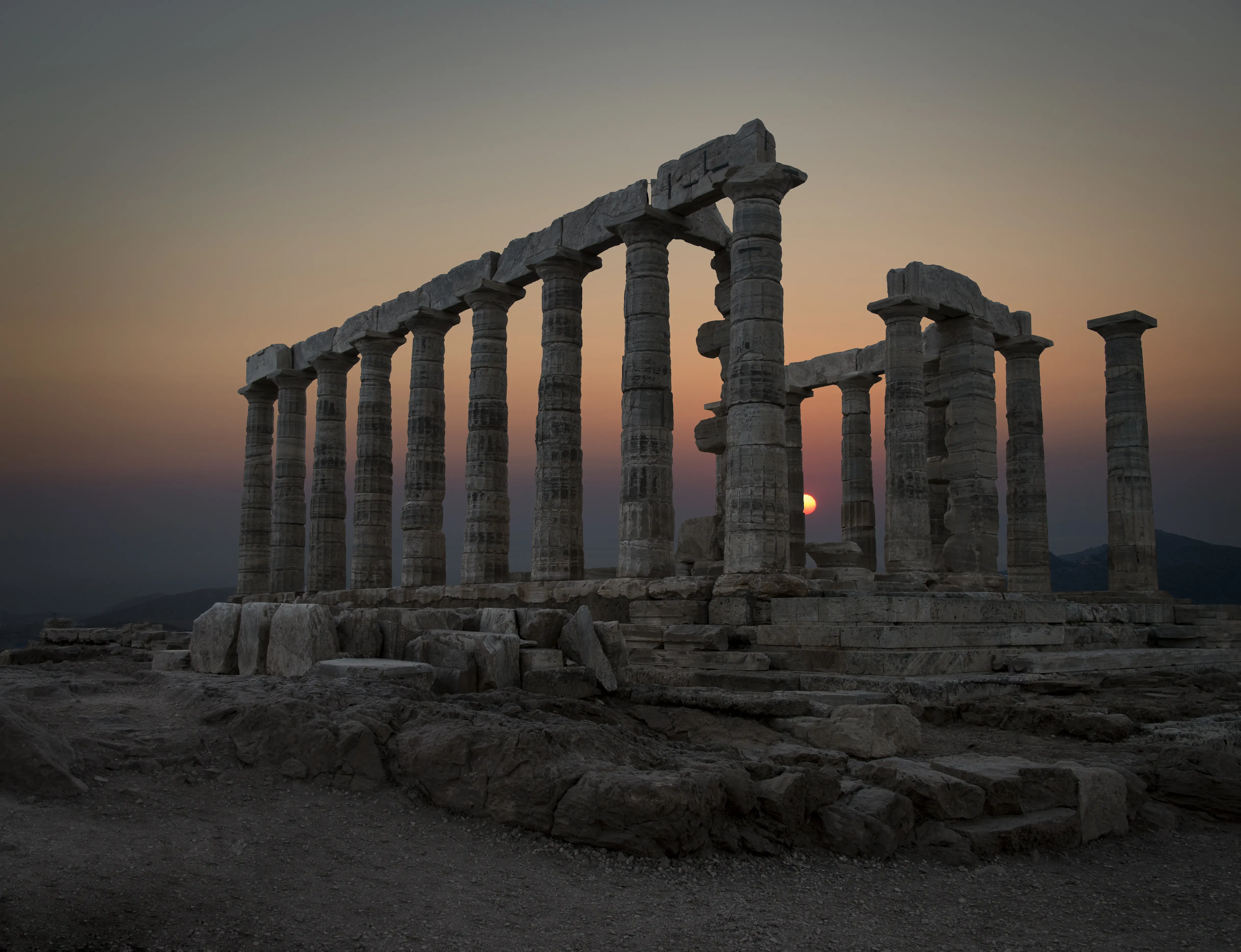 Image of the Temple of Poseidon ruins at sunset.