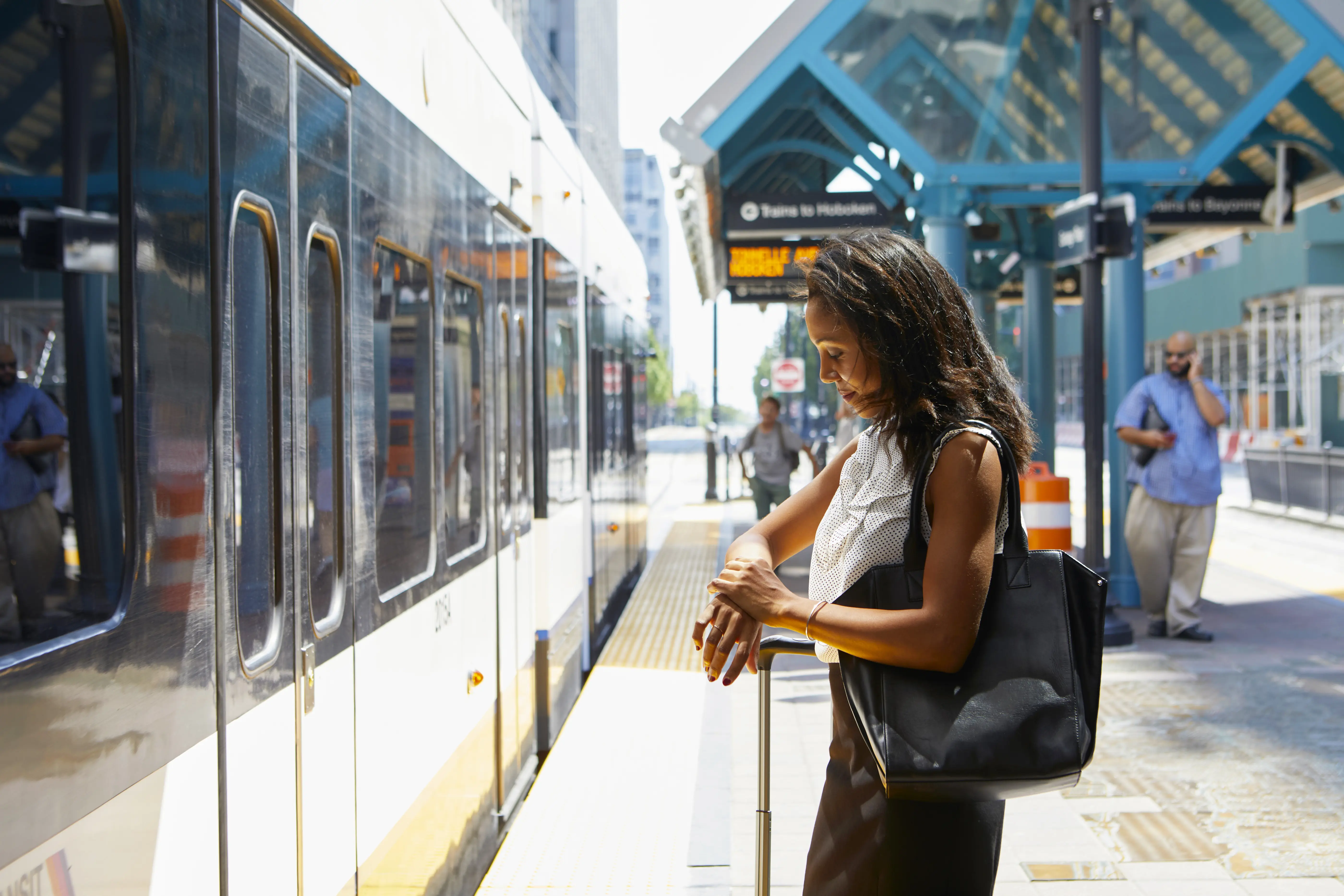 Young woman checking time at light rail station