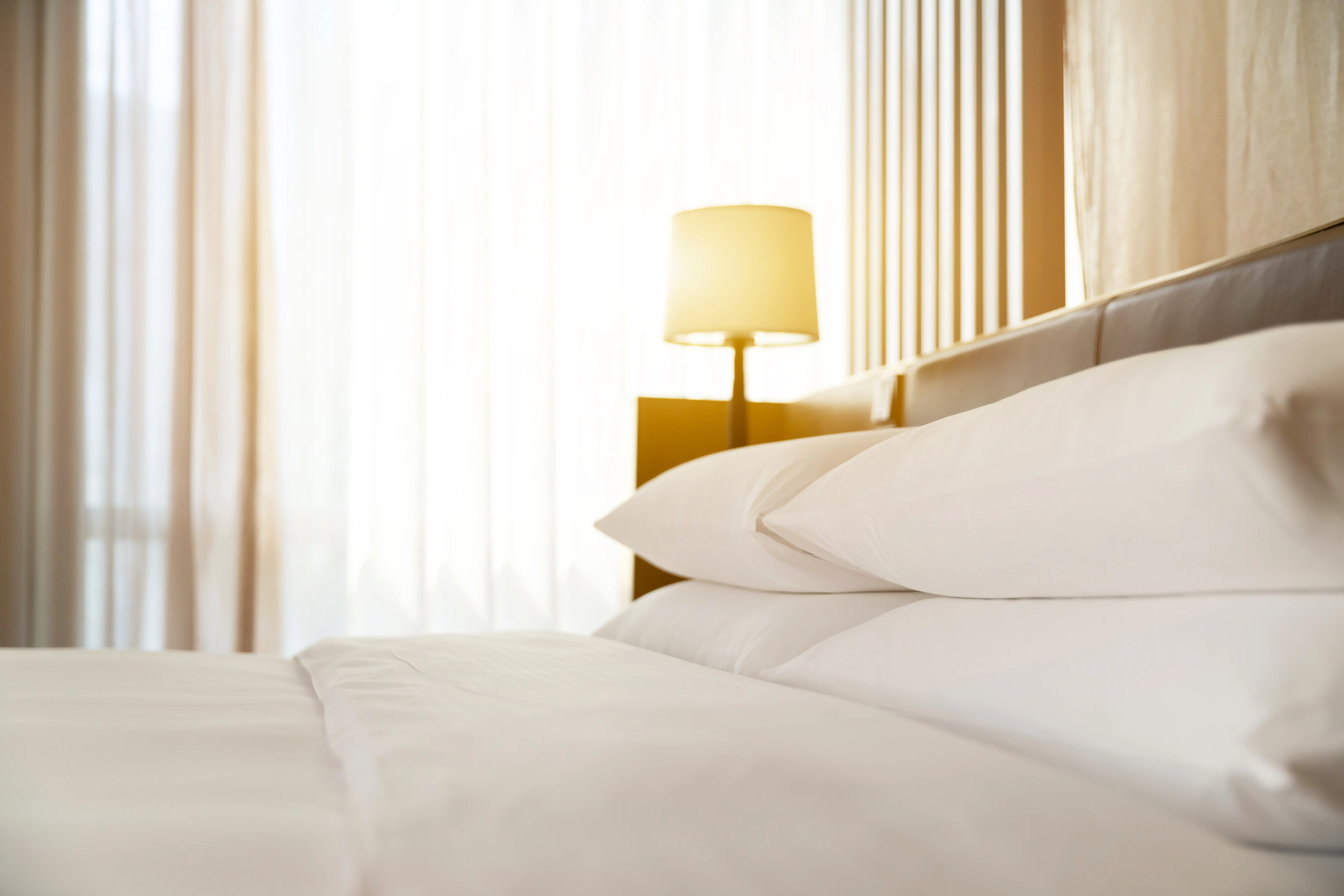 Modern hotel room with white sheets and pillows