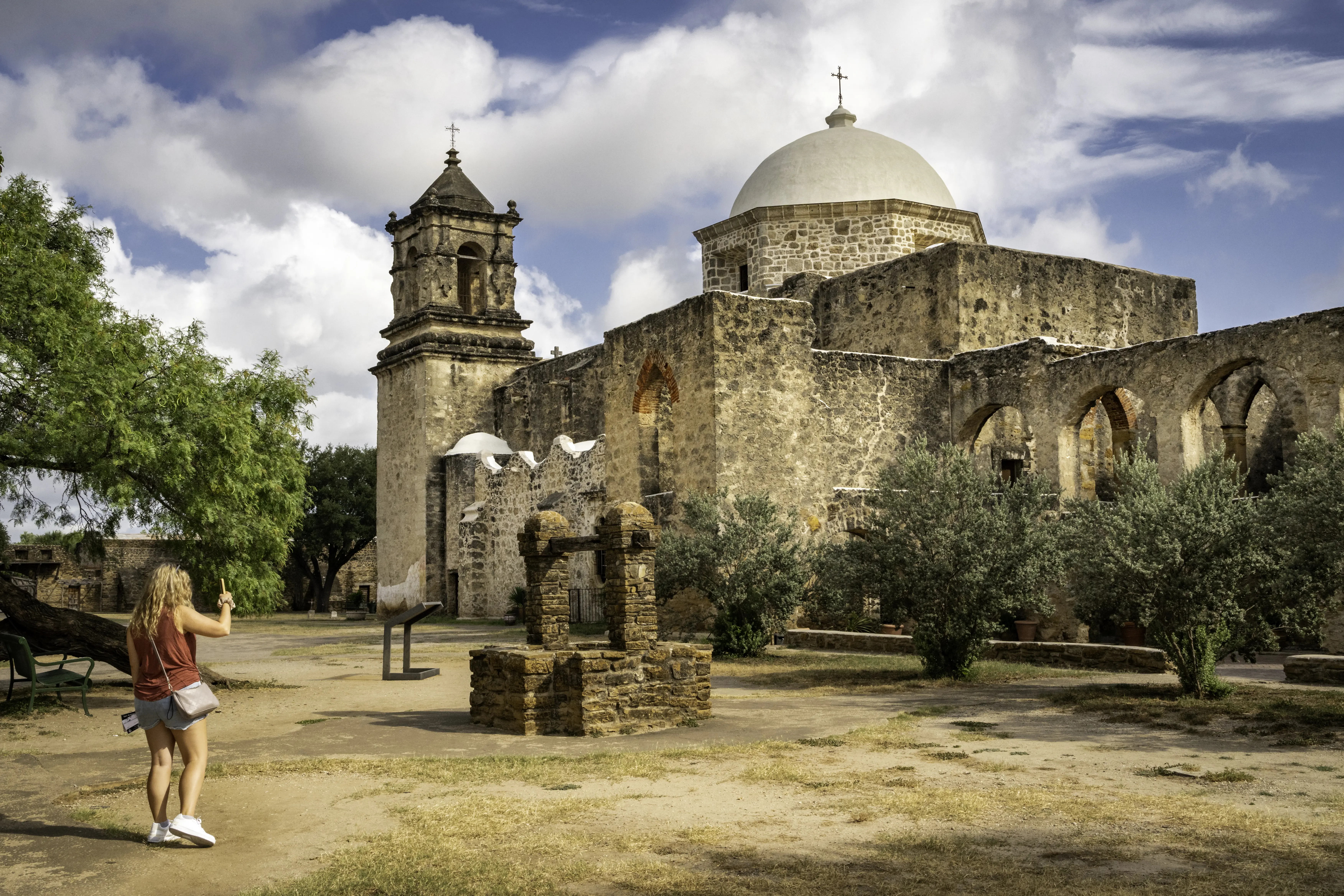 Female tourist photographing Mission San JosÃ©, built in 1720, known as the Queen of the Missions in the historical park, San Antonio, Texas, USA.