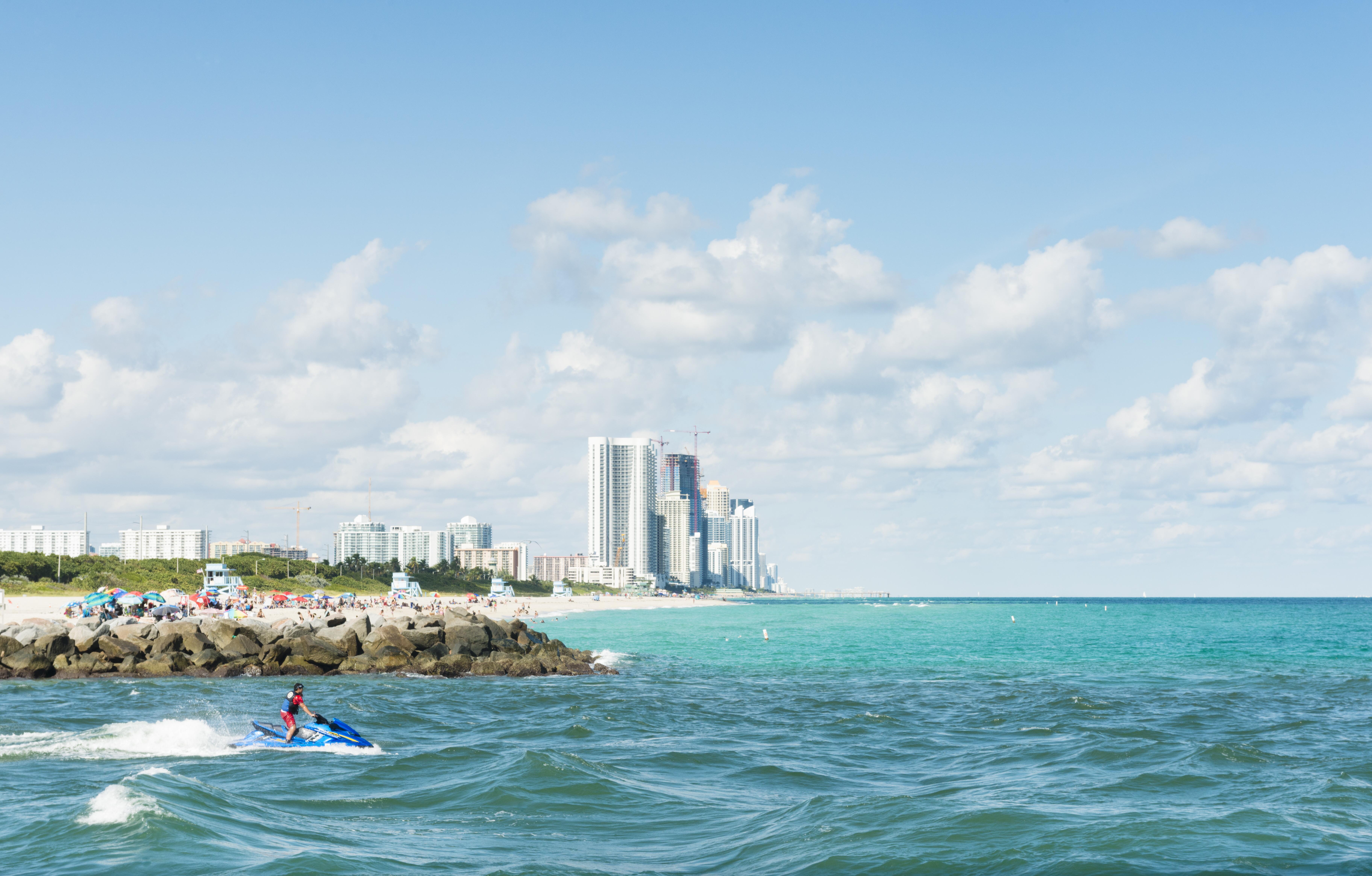 Image of the beach shoreline and a person riding a jet ski at Sunny Isles Beach, Miami.