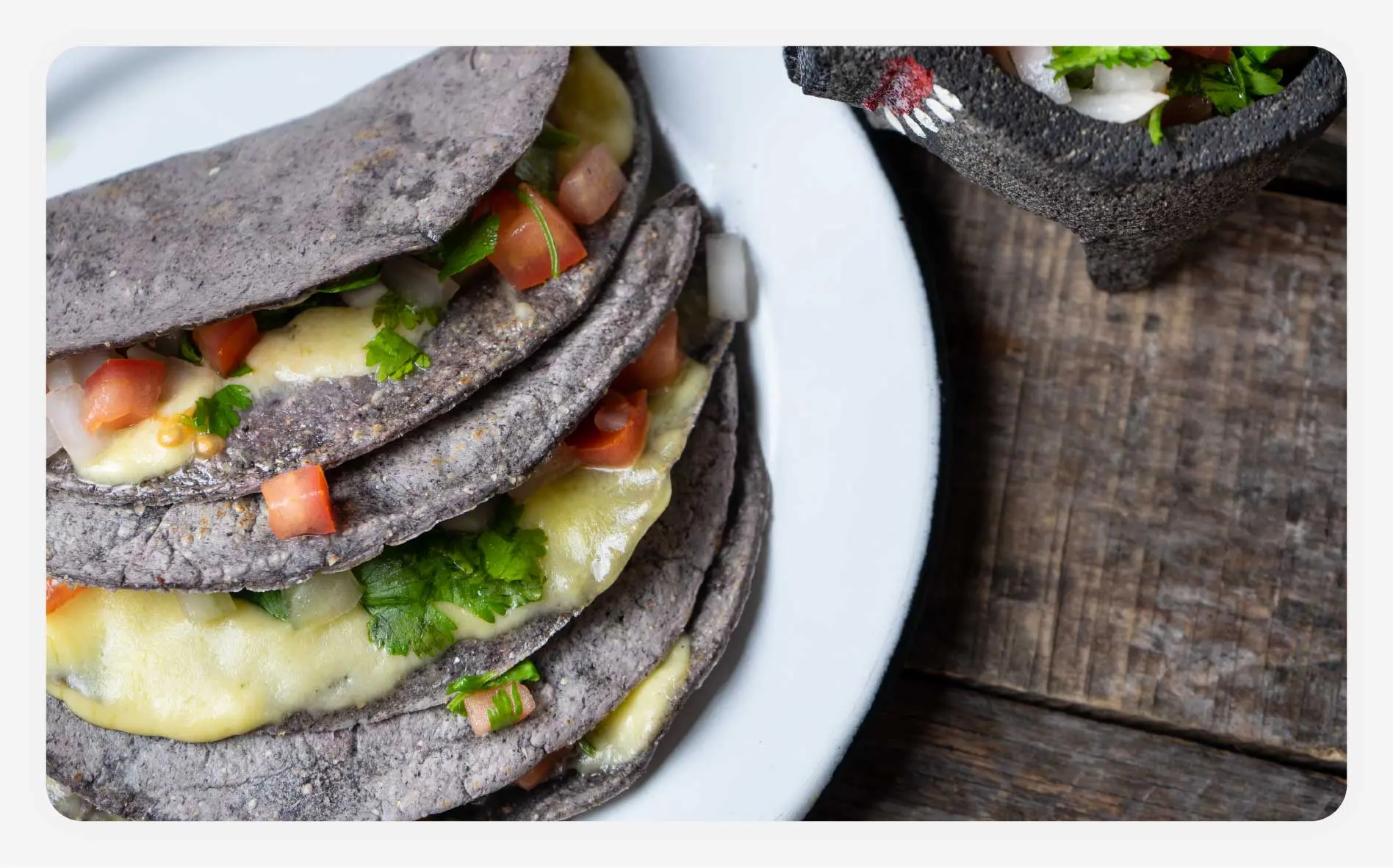 Several blue tortilla tacos on a plate