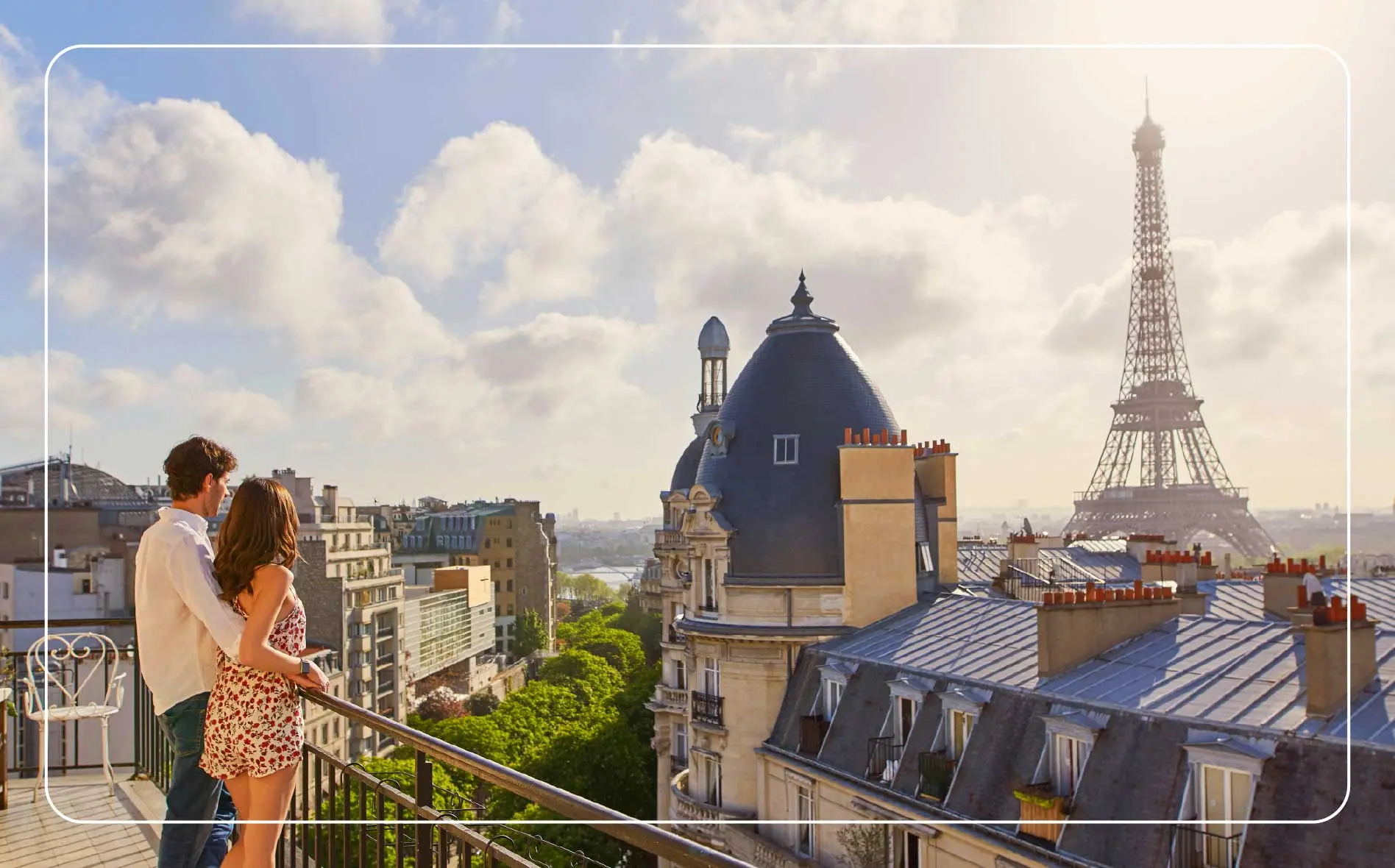 Young couple admiring the view from the balcony of an apartment overlooking The Eiffel Tower in Paris, France.