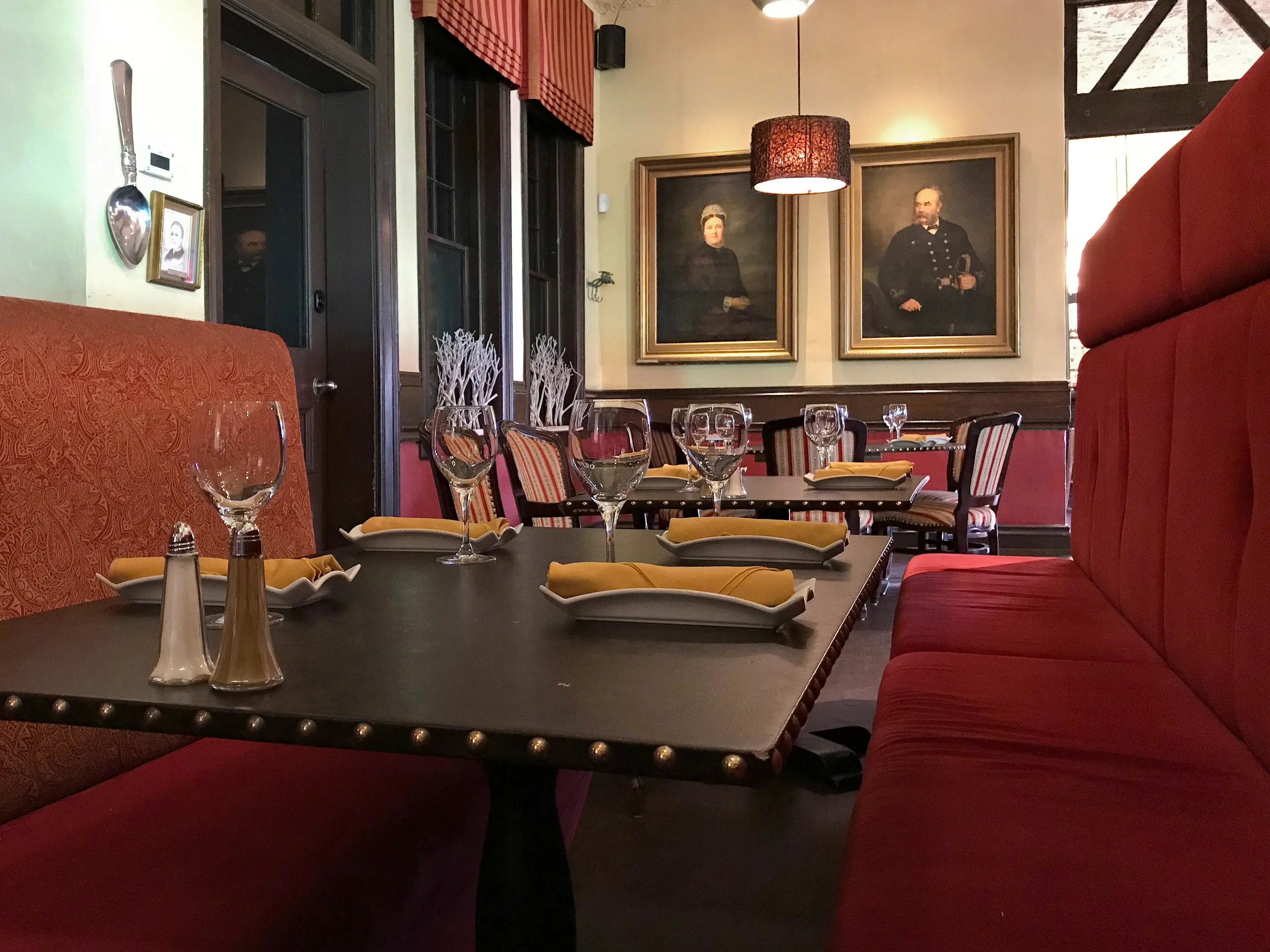 Red upholstered booths and dark wood accents inside the Resto Gare restaurant in Winnipeg, Manitoba.