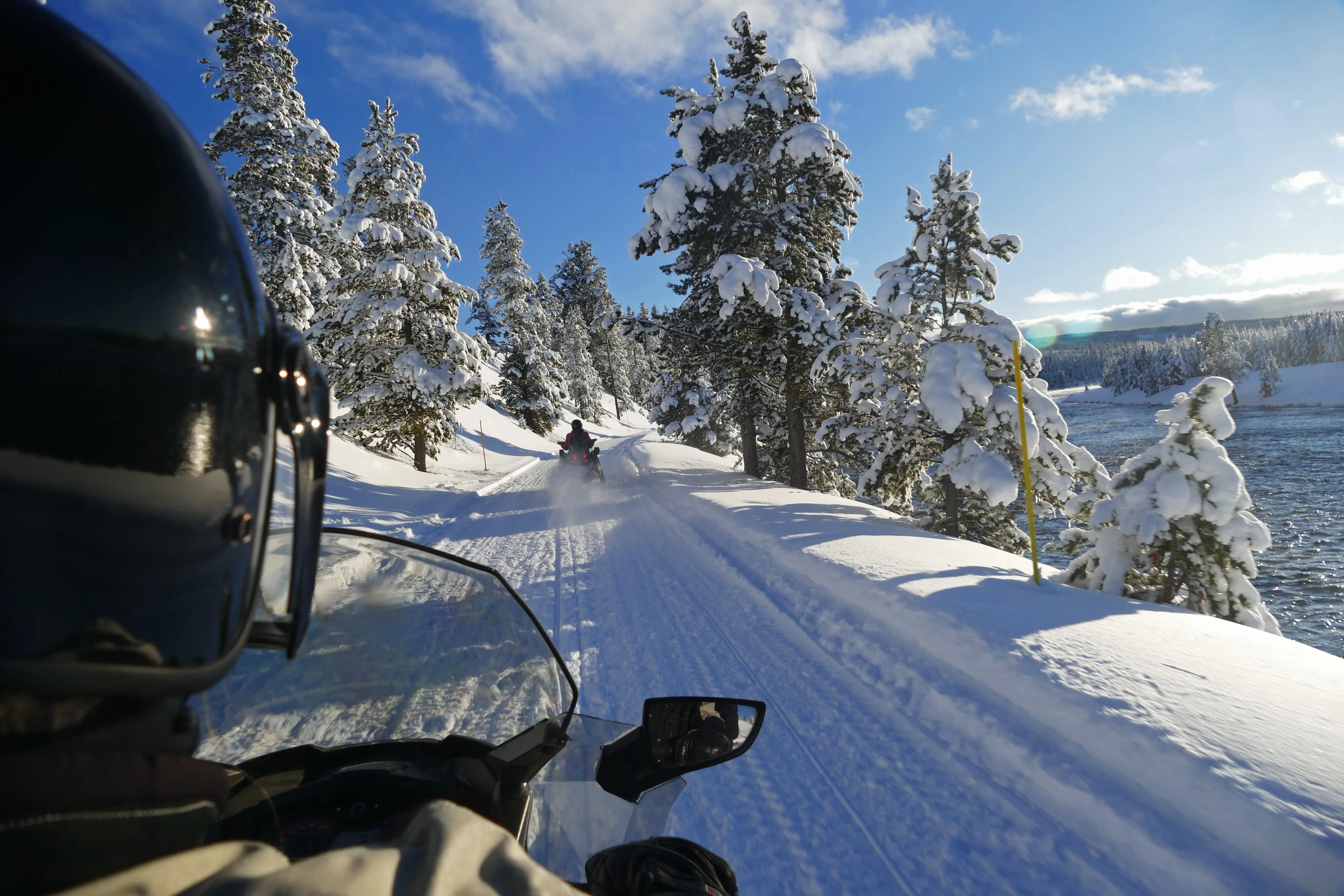 Rider view snowmobiling in the winter along the lake of Yellowstone National Park, Wyoming