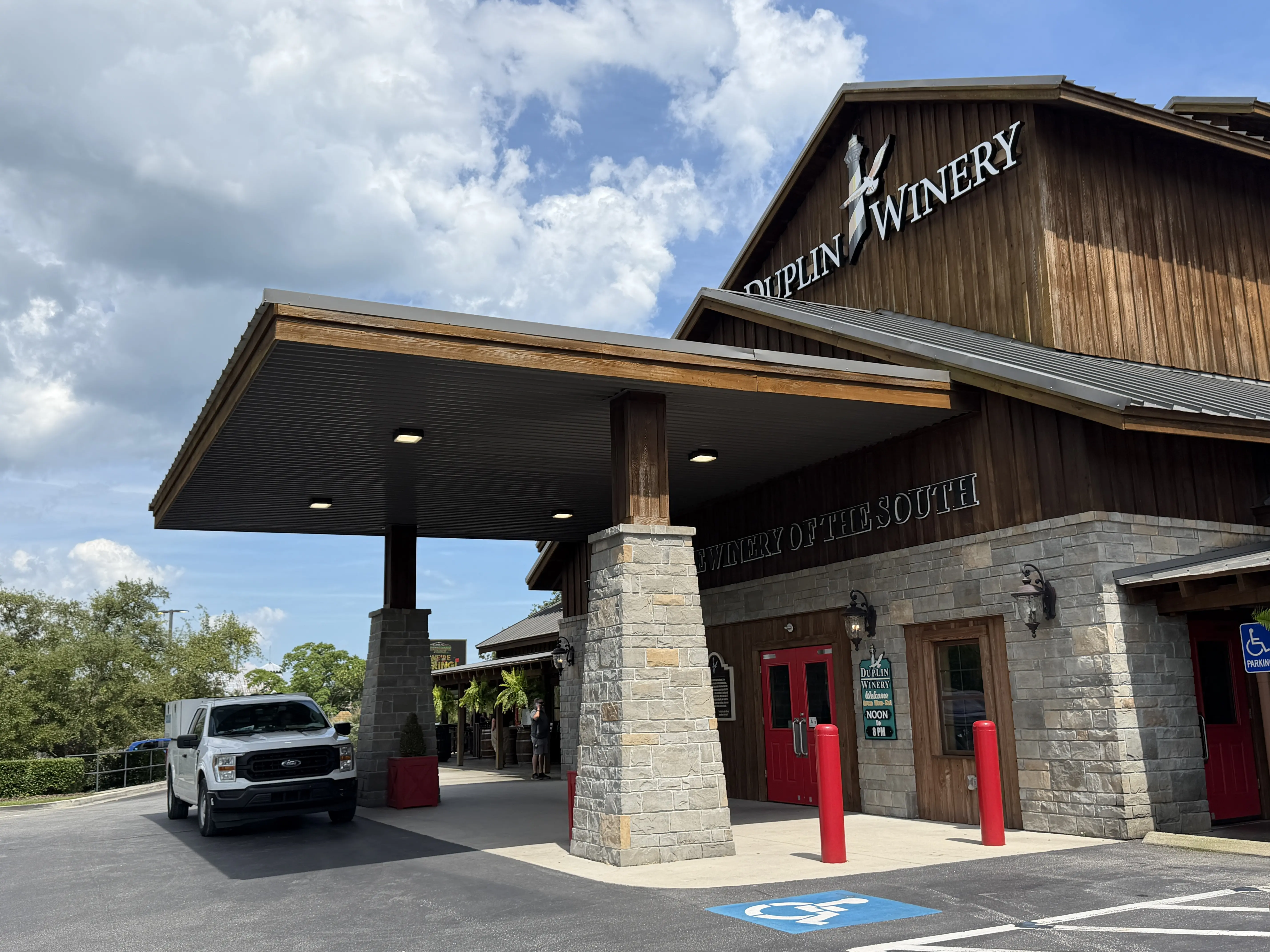 Exterior of Duplin Winery tasting room. First story is grey stone and second story is dark wood vertical cladding.