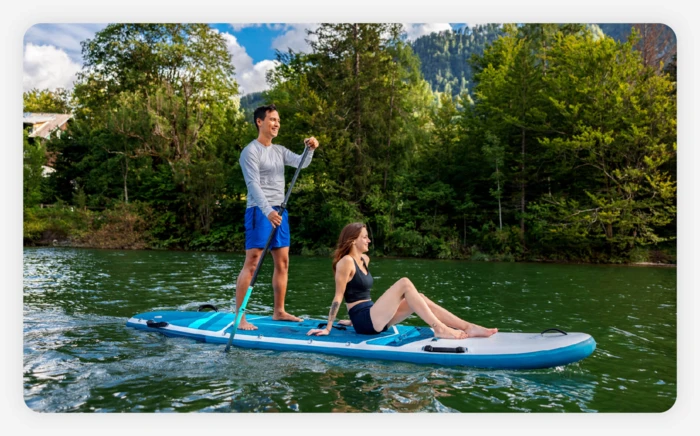 A couple paddleboarding together on a lake